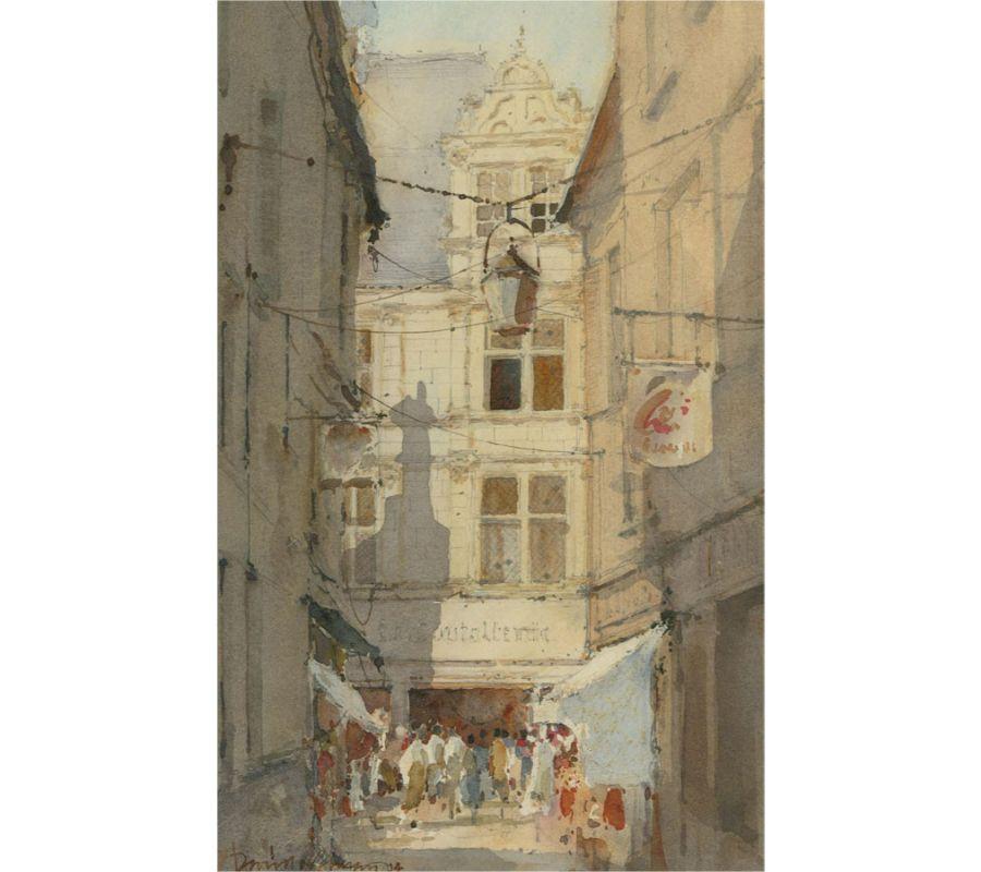 A summery French street scene showing a side street filled with people with shafting sunlight illuminating the architecture. The artist has signed and dated to the lower left corner and the painting has been presented in a brushed silver frame with