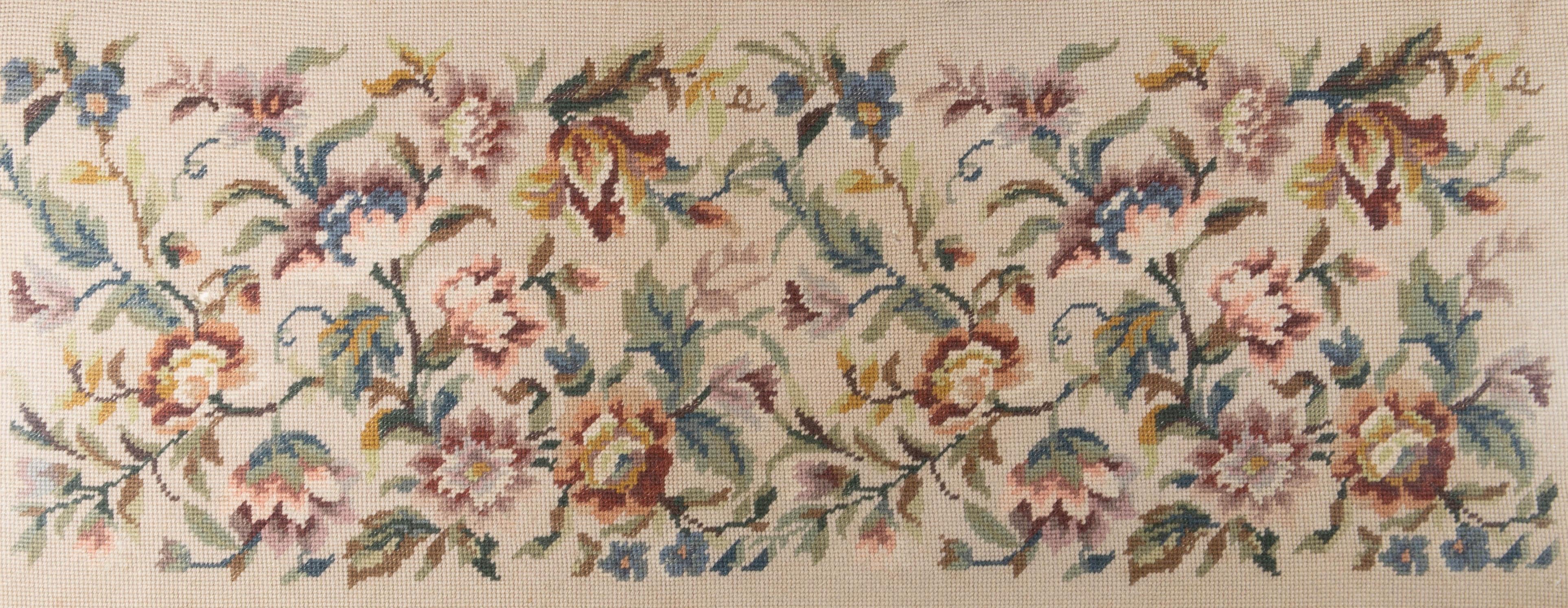 A large work of embroidery depicting flowers and their leaves. Presented glazed in a wooden frame with twisted rope detailing and a gilt-effect inner edge. Unsigned.
