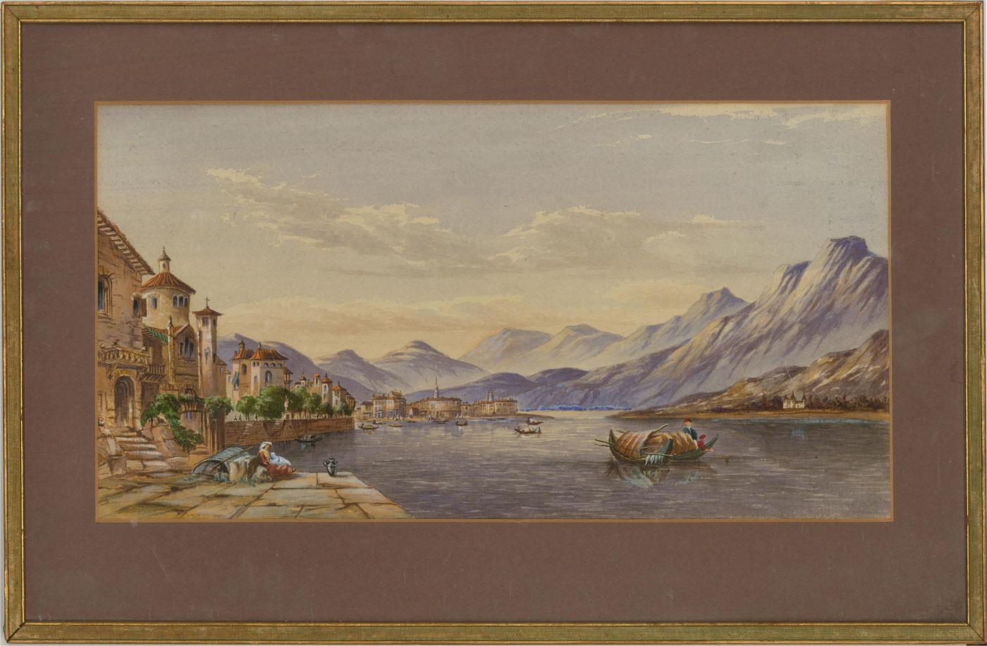 A beautiful Italian lake view, showing a charming lakeside town, the water busy with boats. The lake is surrounded by an impressive mountain range. The painting is unsigned and presented in a contemporary gilt frame with thin linen cove. brown card
