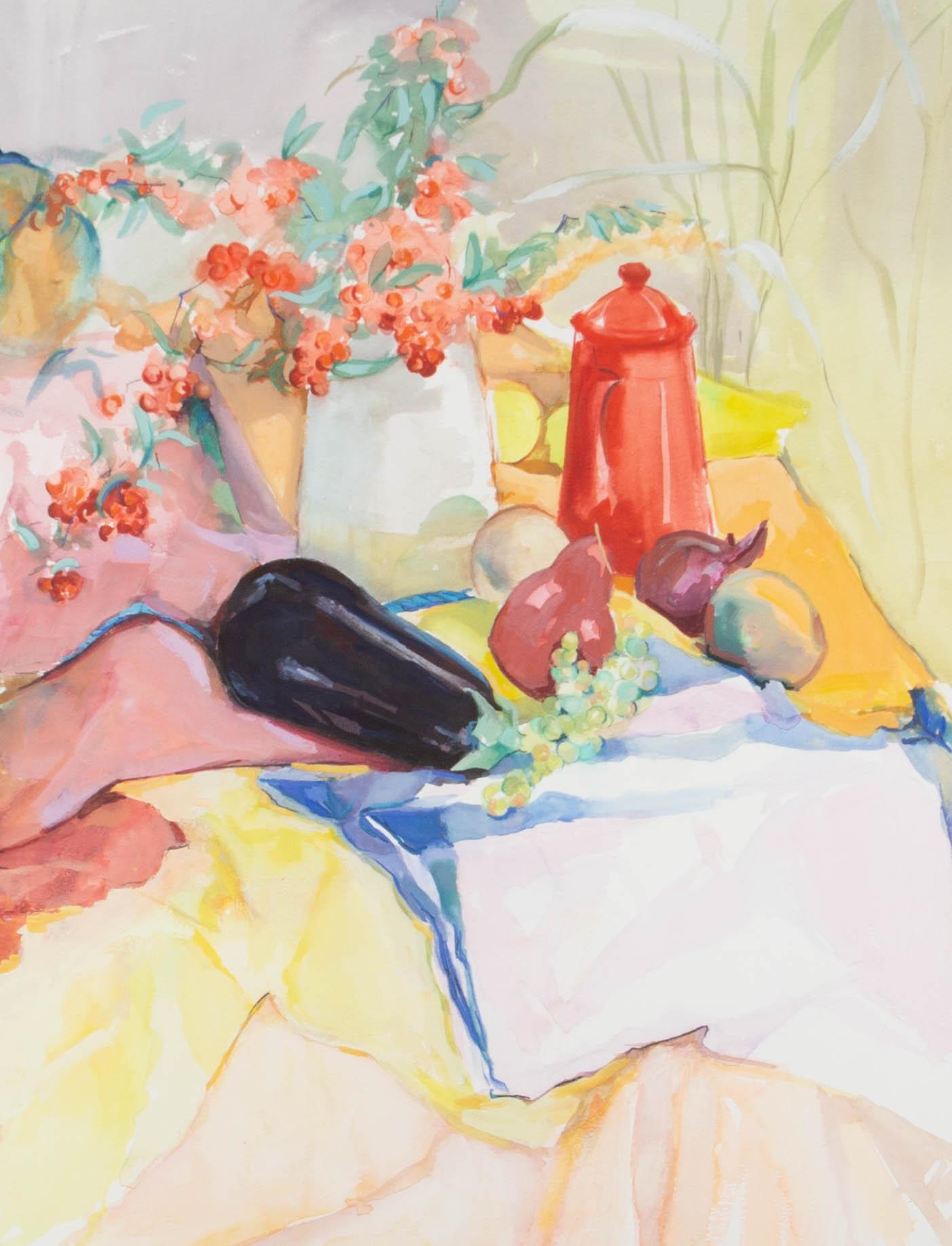 A vibrant and utterly engaging still life in watercolor showing a joyful display of fruit, vegetables and a shiny red coffee pot on an array of colorful drapery. The artist has signed to the lower right and the painting has been attractively