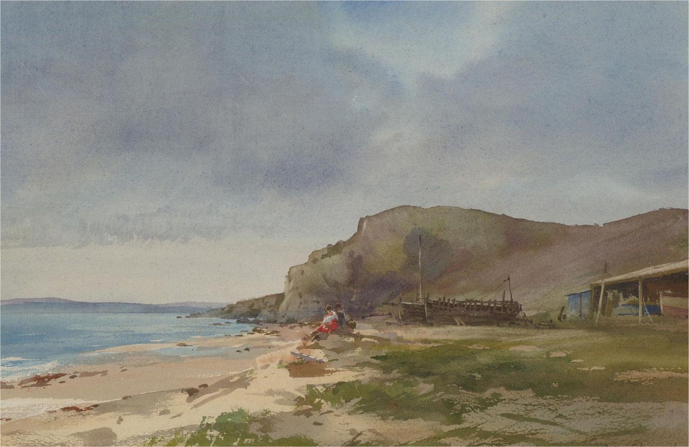 A fine coastal watercolour scene showing two figures, lit by soft sunshine, resting on rocks on the shore of the Isle Of Mann. The artist has signed to the lower right and the painting has been presented in a gilt frame with beaded strap work and a