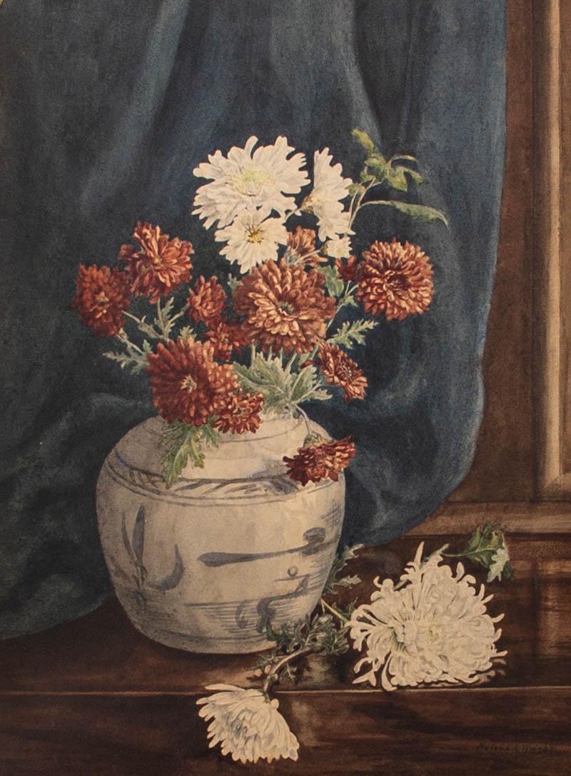 A delicate and finely executed floral still life of red and white chrysanthemums in a blue and white china urn in front of a deep blue curtain. The artist has executed the naturalistic lighting and simple composition with a restrained and skilled