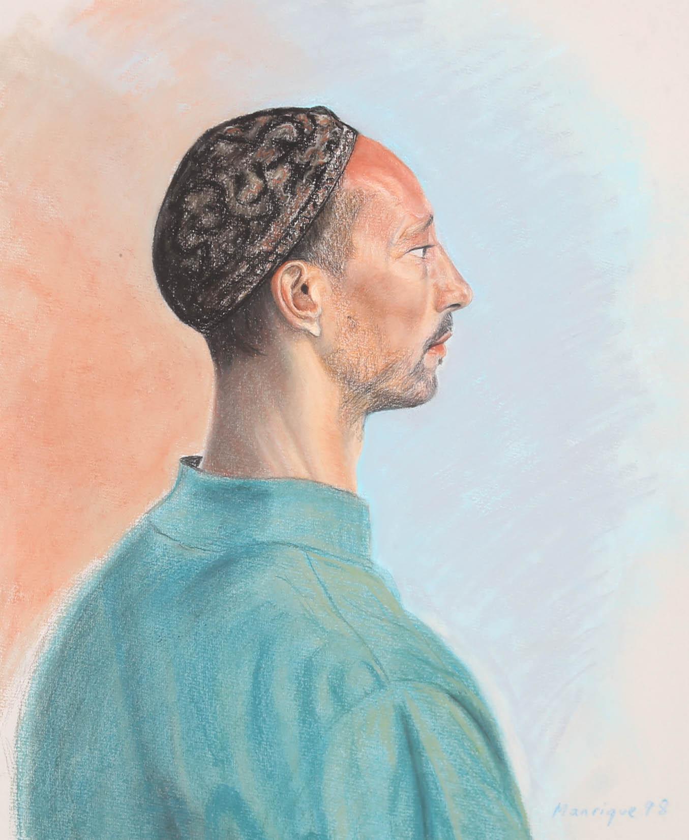 This colourful portrait depicts the profile of a man wearing a blue tunic and a kufi. The artist captures the man in fine pastel detail, highlighting the hyper realistic tones and in his face and clothing. He is portrayed against a soft blue and