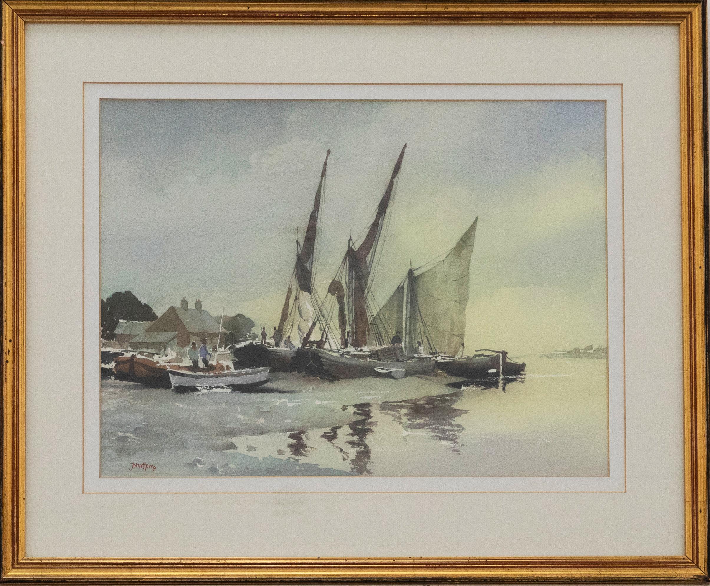 A serene watercolour scene of sailing barges beach to the side of an estuary at sun down. Signed by the artist to the lower right. Well-presented in a double card mount and gilt-effect frame. On watercolour paper.
