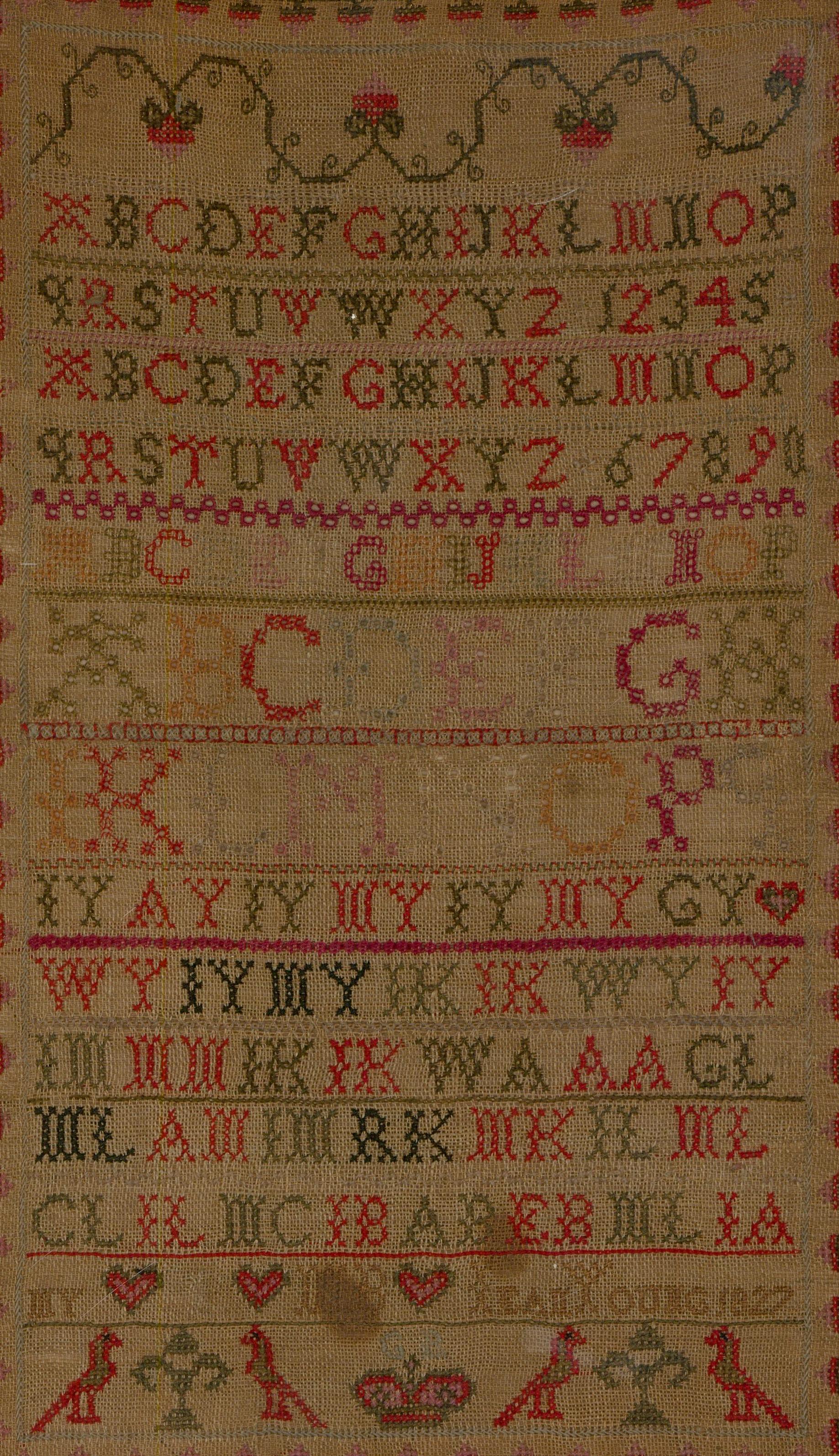 A beautiful George VI sampler, hand embroidered by Leah Young in 1827. Cases of the alphabet, birds and heart motifs have all been created from open stitch, cross stitch, and stem stitch techniques. Well-presented under glass in a black and gilt