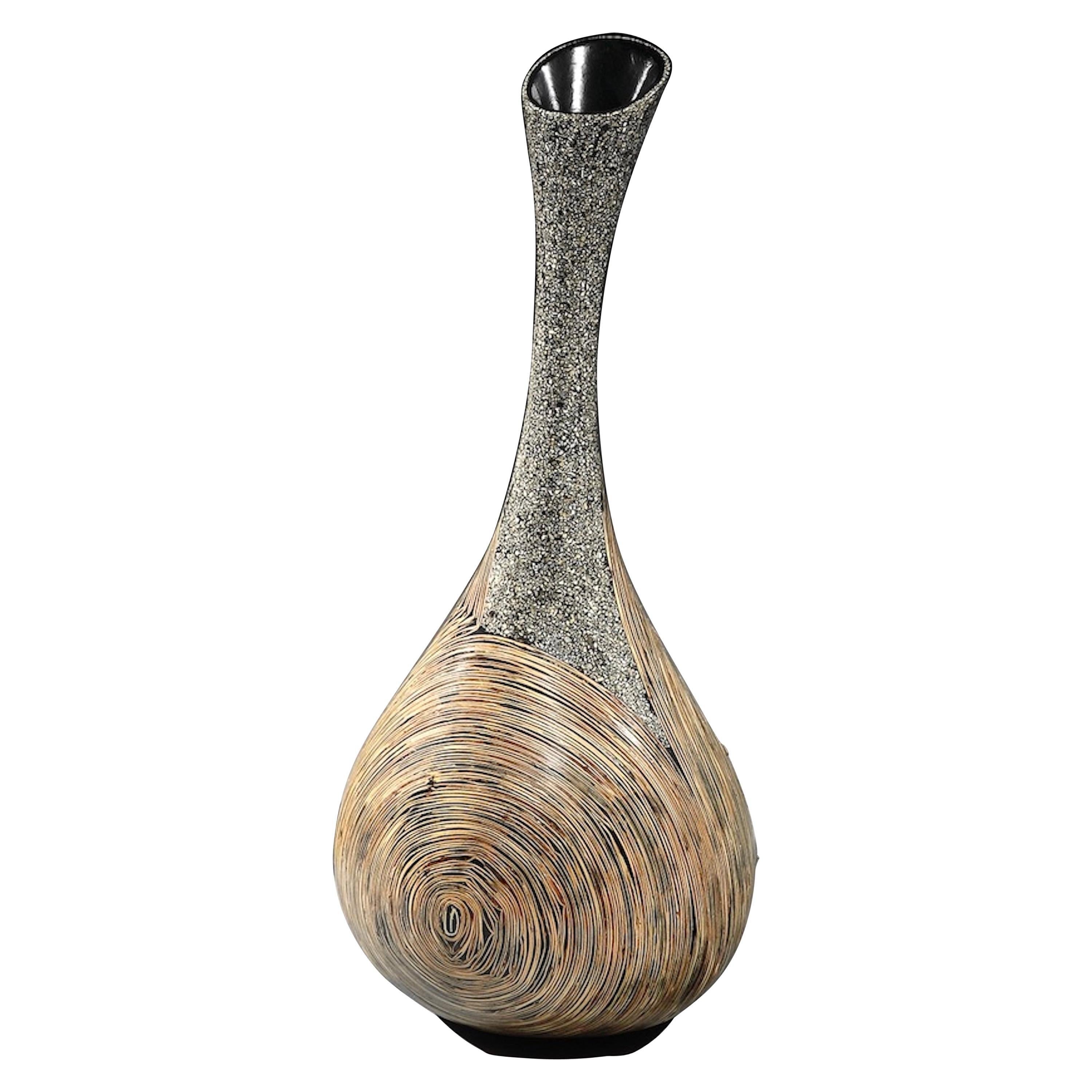 Lusia Robinson: Infinity Vase 
- This vase is characteristic of Robinson’s work emphasizing materiality within form integrating indigenous materials with modern technology and applications 
- The open lip, sweeping neck and round body create a fluid