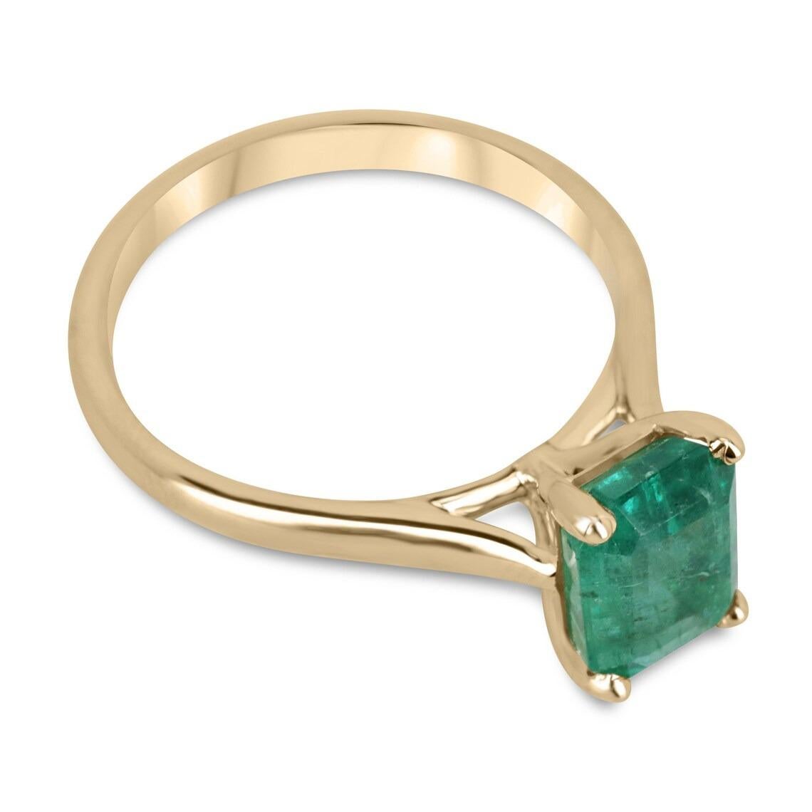 Displayed is a classic emerald solitaire emerald-cut engagement ring/right-hand ring in 14K yellow gold. This gorgeous solitaire ring carries a full 2.25-carat emerald in a four-prong setting. Fully faceted, this gemstone showcases excellent shine.