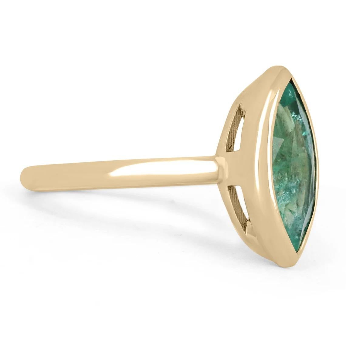 Displayed is a stunning natural emerald, marquise cut gold ring. This custom piece is extremely unique, as having emeralds cut in these rare shapes is very uncommon. This natural emerald marquise showcases gorgeous medium green color and good