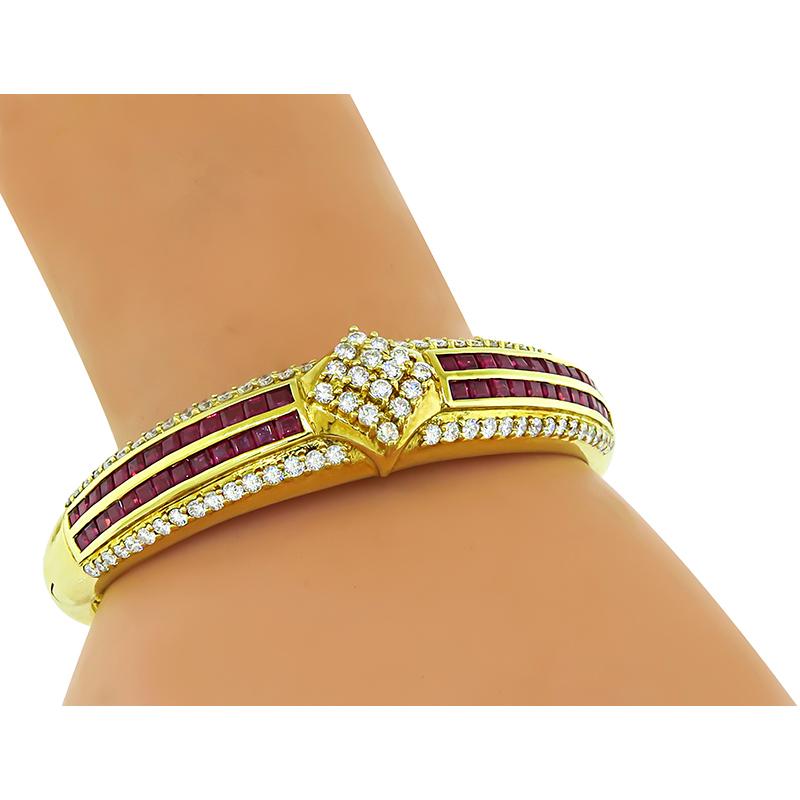 This is an elegant 18k yellow gold bangle. The bangle is set with sparkling round cut diamonds that weigh approximately 2.25ct. The color of these diamonds is G with VS clarity. The diamonds are accentuated by square cut rubies that weigh
