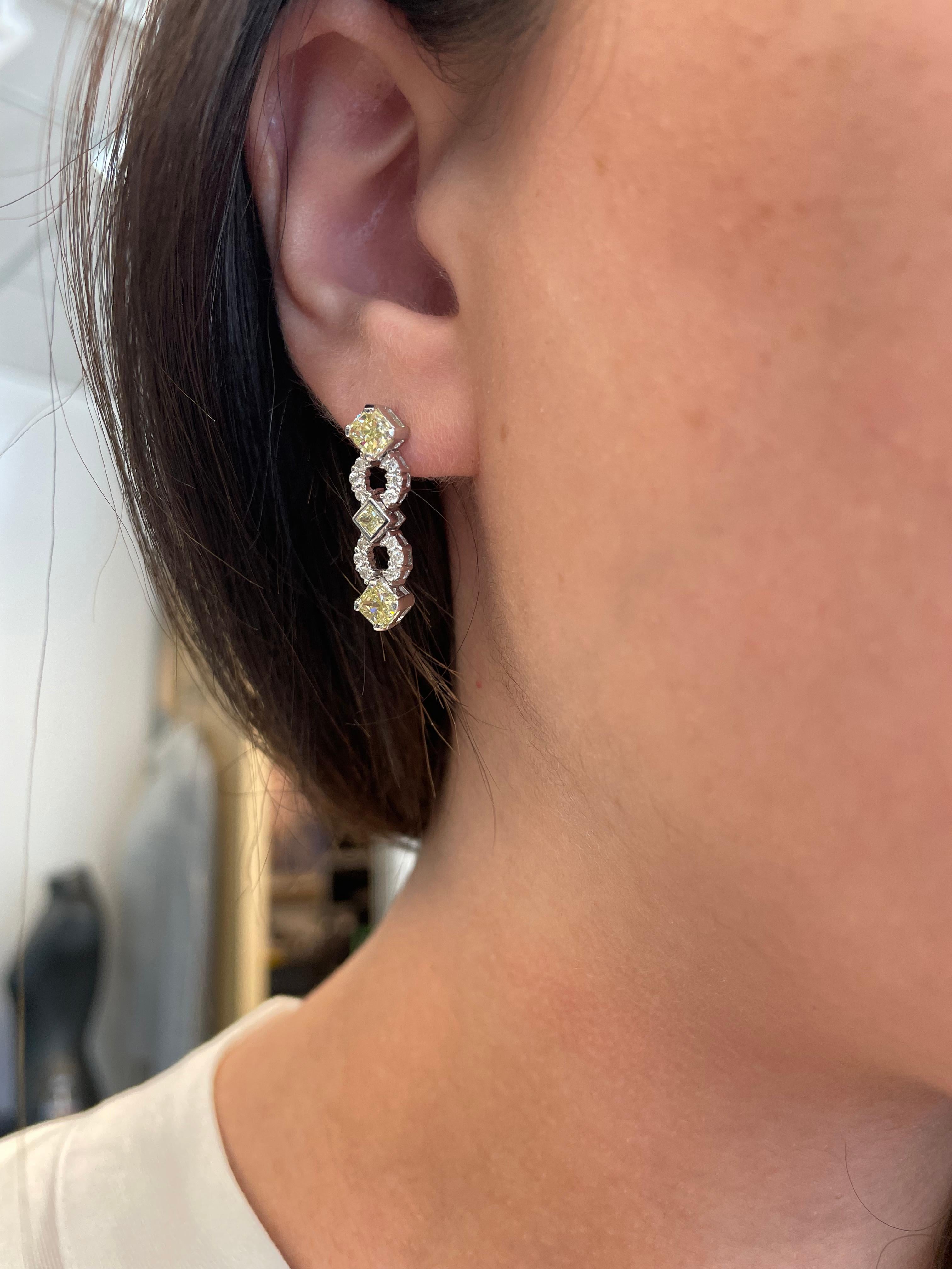 Lovely yellow diamond earrings. 
6 radiant cut diamonds, 2.25 carats. Approximately Fancy Light Yellow color and SI clarity. 0.35 carats of round brilliant diamonds, approximately H/I color and SI clarity. 18-karat white gold, 7.10 grams.
2.60
