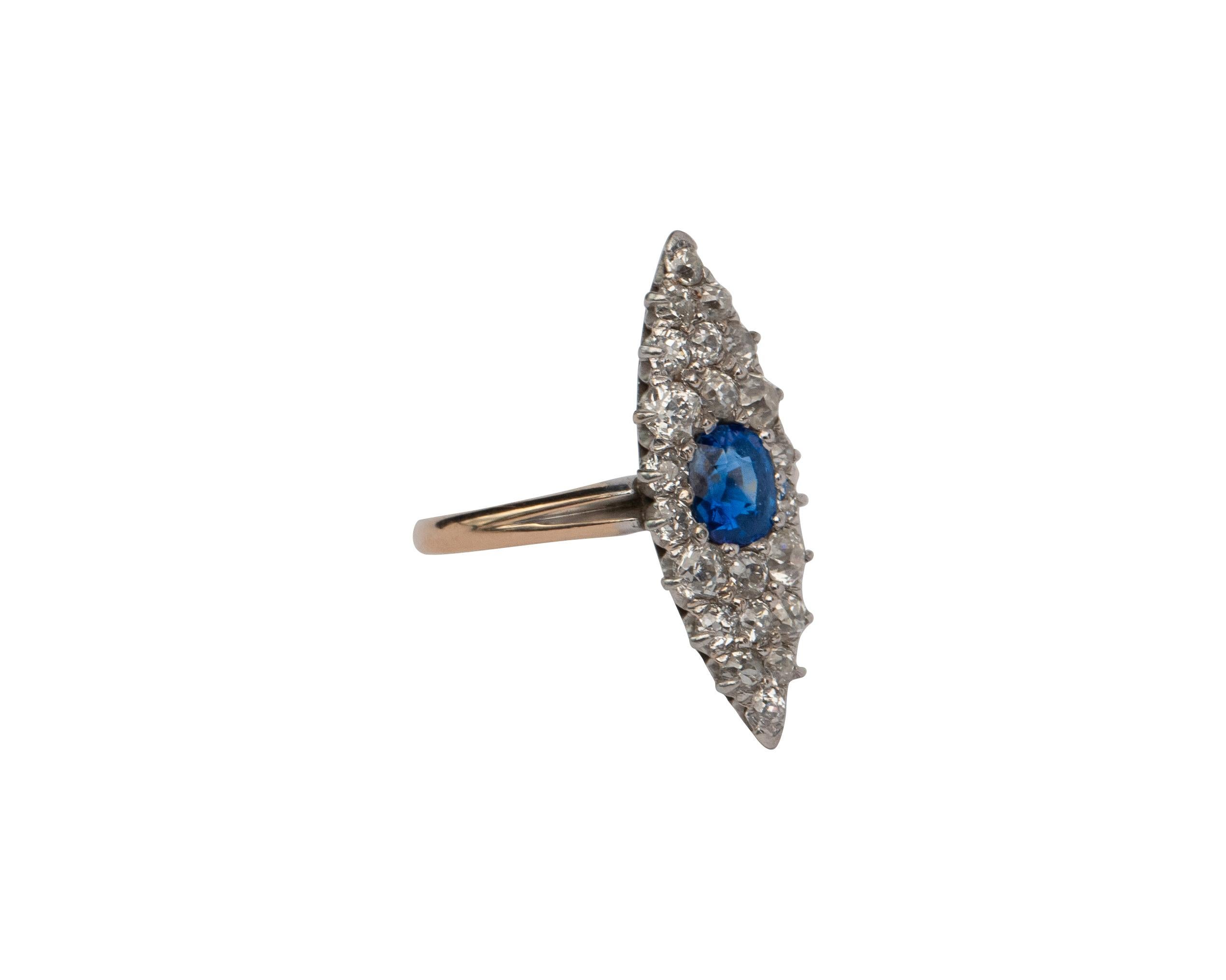 This is an exquisite example of a victorian navette marquise-shaped ring. It is crafted in yellow gold with a platinum top. The center features a dreamy natural blue sapphire of the finest quality. The sapphire in surrounded by 1.25 carats of