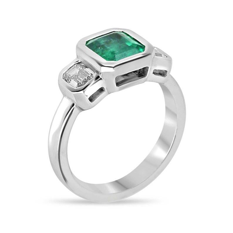 Indulge in opulent sophistication with our breathtaking emerald and diamond three-stone ring, featuring a mesmerizing GIA-certified natural emerald as the centerpiece, boasting a lush medium-dark green hue and transparent clarity. Flanked by two