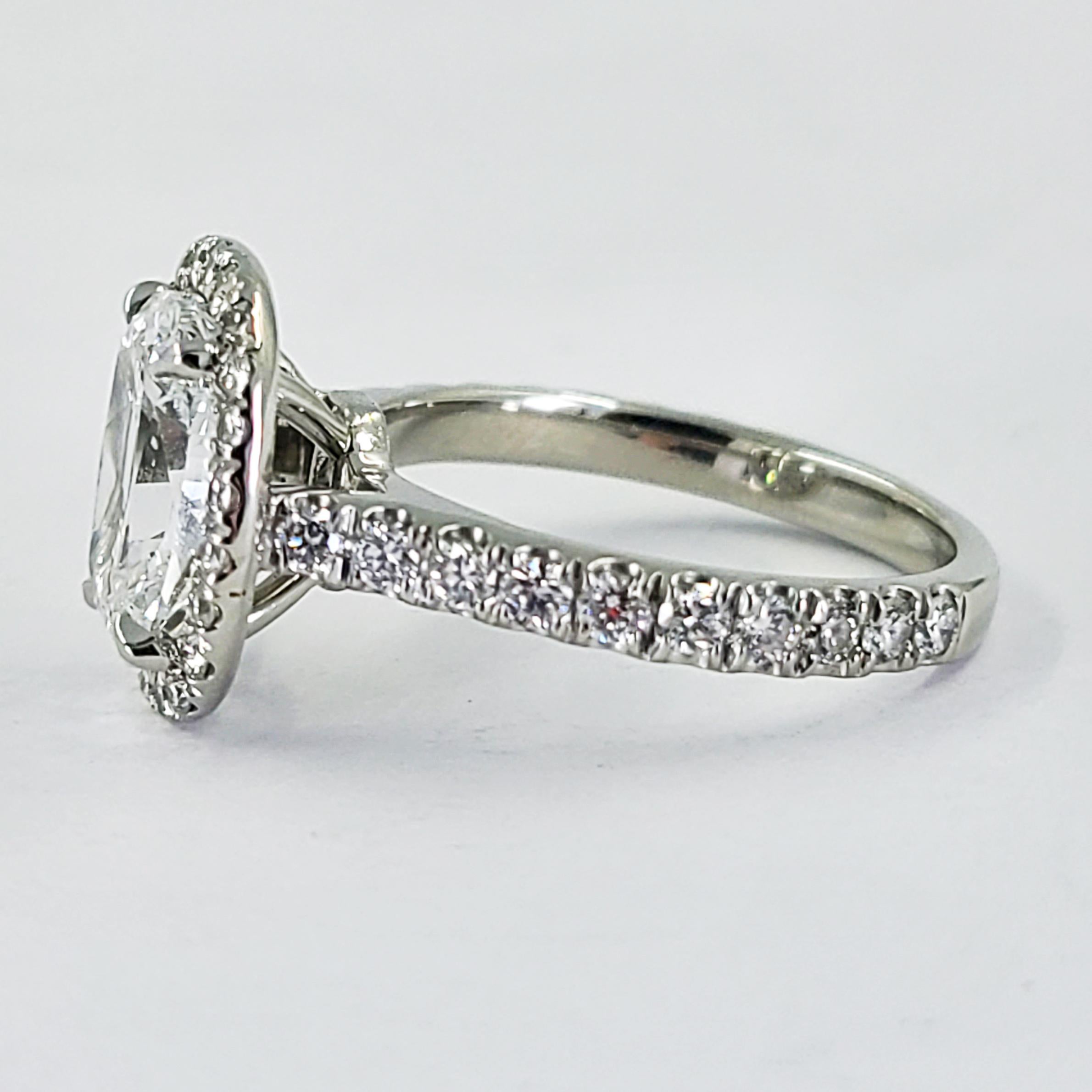 Platinum Halo Engagement Ring Featuring A 2.26 Carat Cushion Cut Diamond GIA Graded (Report #2131718400) As E Color & SI2 Clarity Accented By 42 Round Brilliant Cut Diamonds Of VS Clarity & F/G Color Totaling An Additional 0.74 Carats. Current