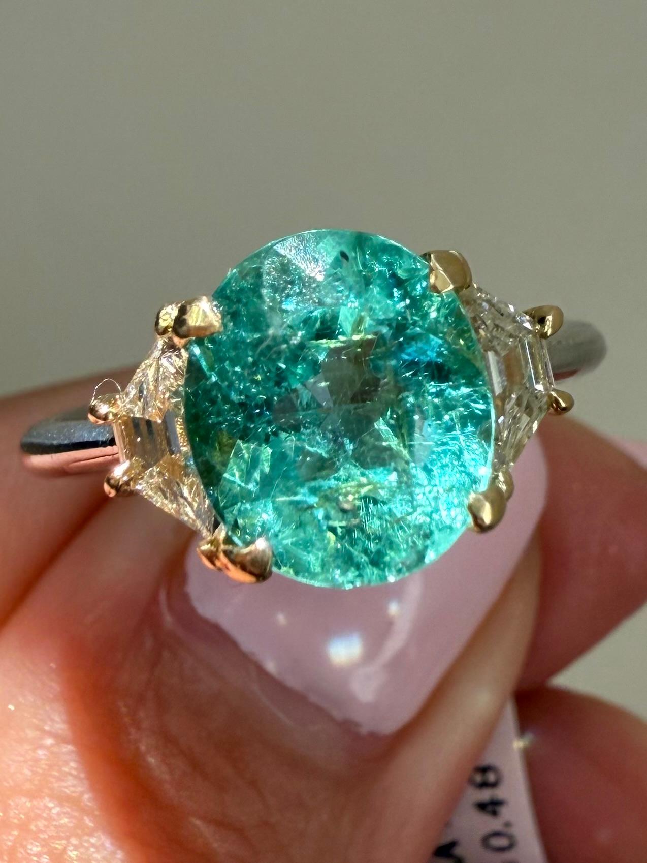 Cette époustouflante bague à trois pierres est ornée d'une tourmaline Paraiba ovale de 2,26 carats, une pierre précieuse très prisée pour son éclat bleu-vert électrique, qui ne ressemble à aucune autre au monde. Le Lumin est magnifiquement serti en