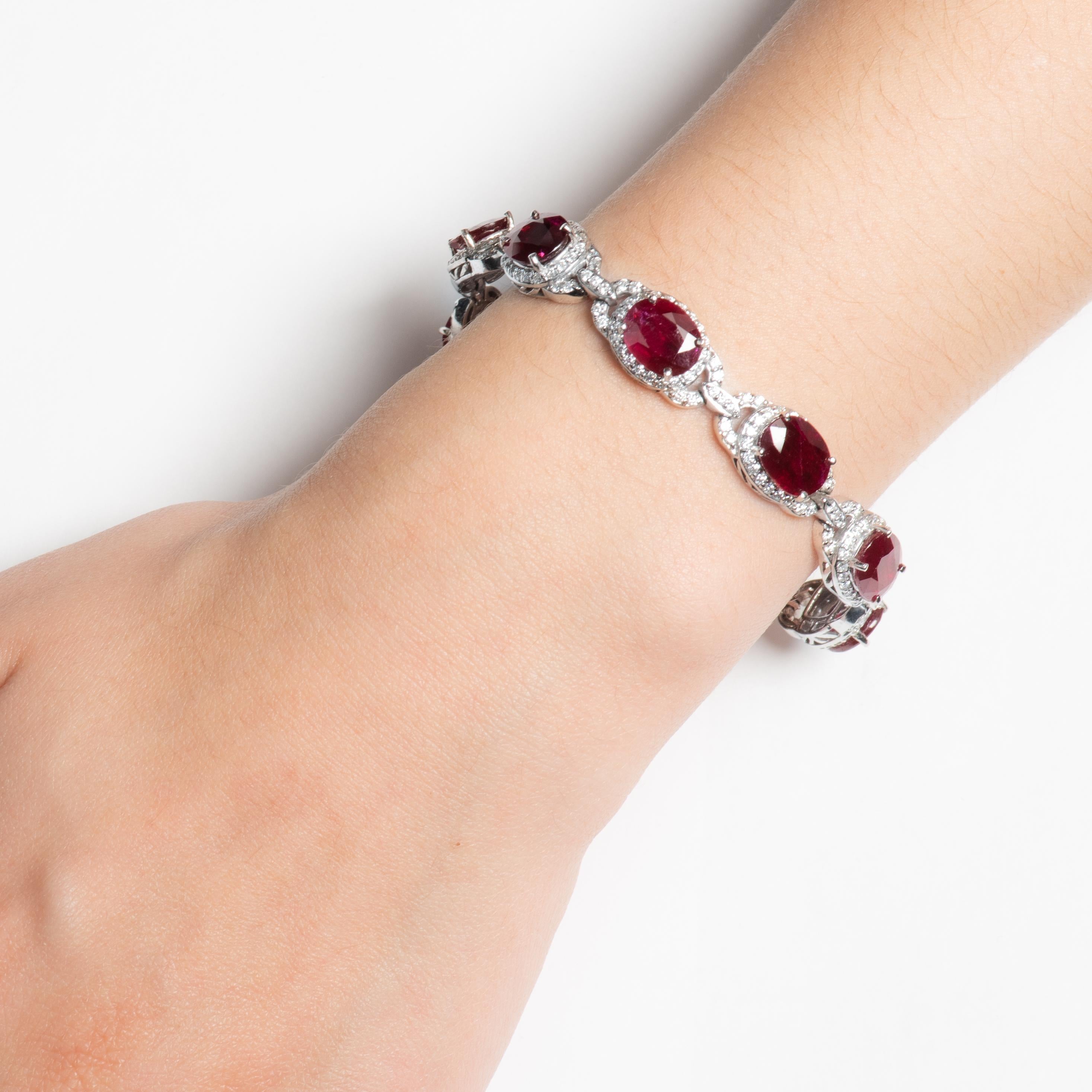 This exquisite bracelet features 22.63ct total weight in oval shaped, intensely red rubies surrounded by 3.44ct total weight in round pave diamonds, linked together. These stones are all set in a 14kt white gold 6.5 inch bracelet. 