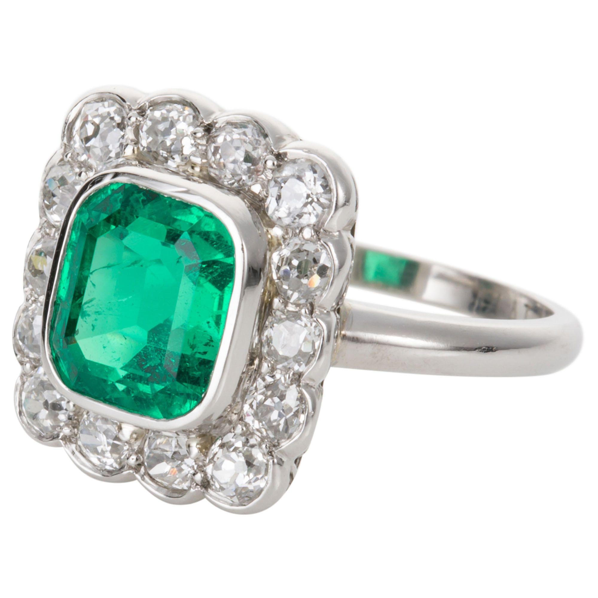 What a magnificent ring - a glorious green step cut emerald weighing 2.27cts surrounded with old European cut diamonds, G colour VS clarity and mounted in platinum. The emerald is certified as originating from Colombia - Natural Beryl with minor