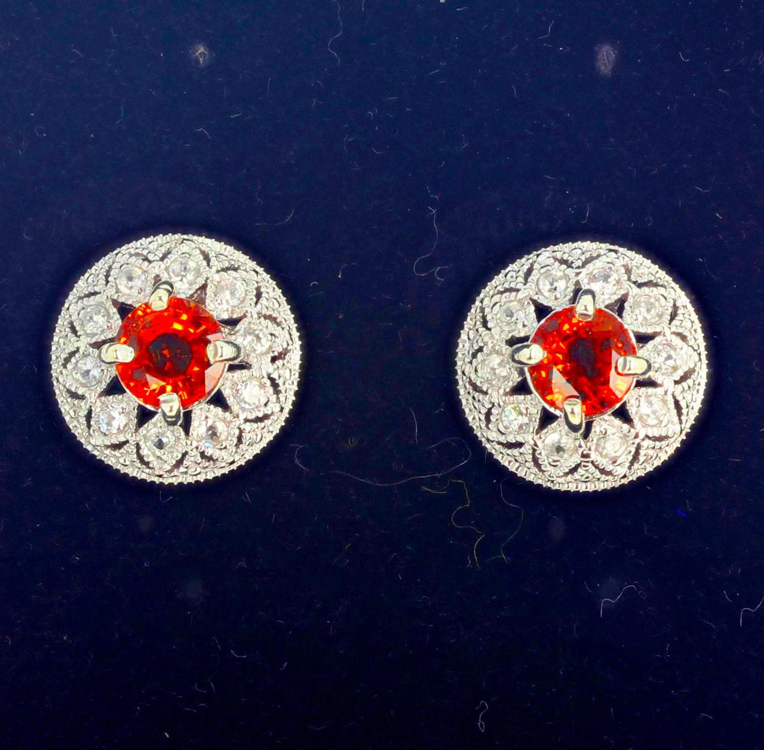 These brilliant orangy red glittering Songea Sapphires ((6mm) are set with accents of brilliant teeny tiny Diamonds in platinum plated sterling silver stud earrings.  The earrings are approximately 13 mm in diameter.  