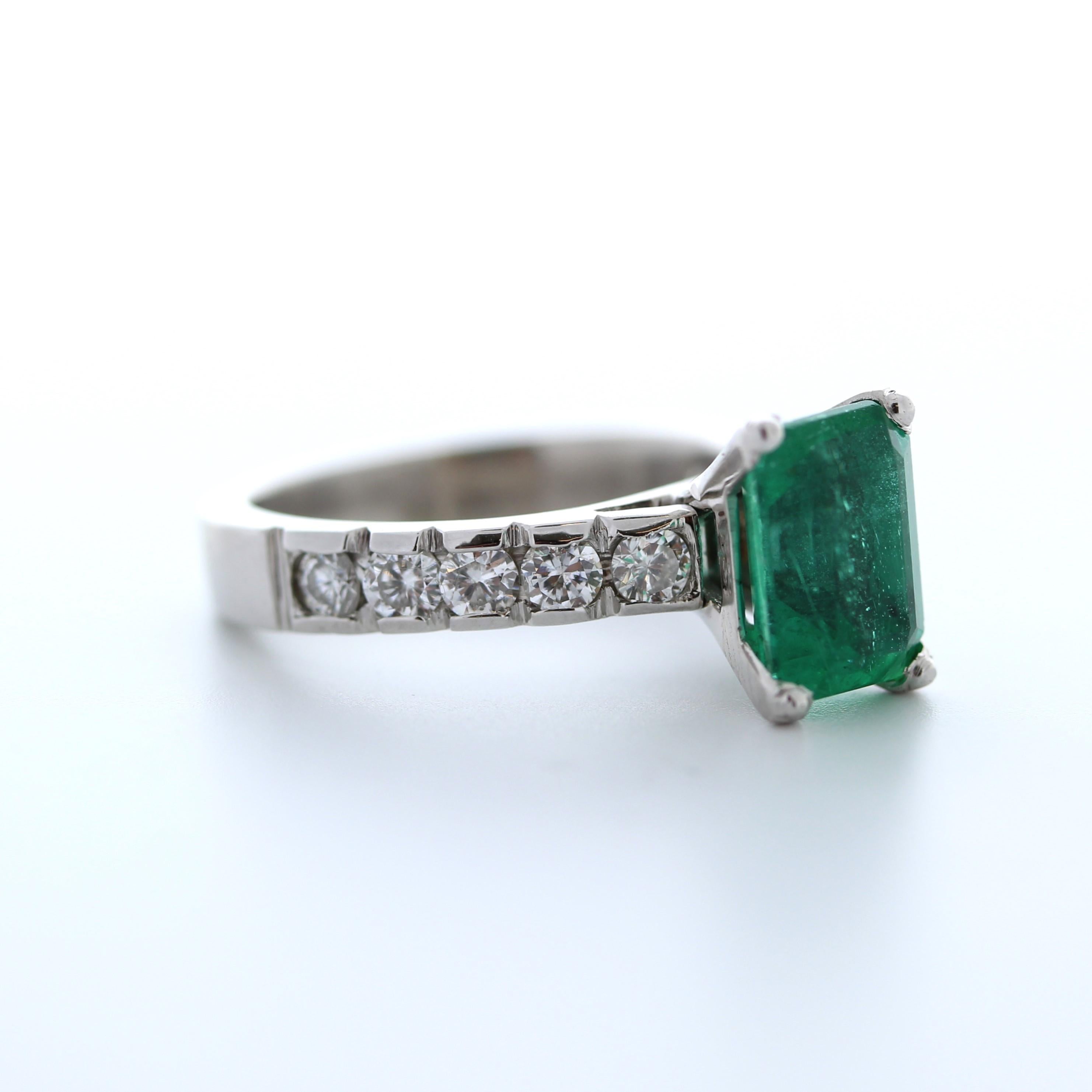 The 2.27 Green Emerald & Round Diamond Fashion Ring is a stunning piece of jewelry made from 14K white gold. The ring features a green emerald stone as its centerpiece, which is surrounded by ten round diamonds, totaling 0.90 carats. The diamonds