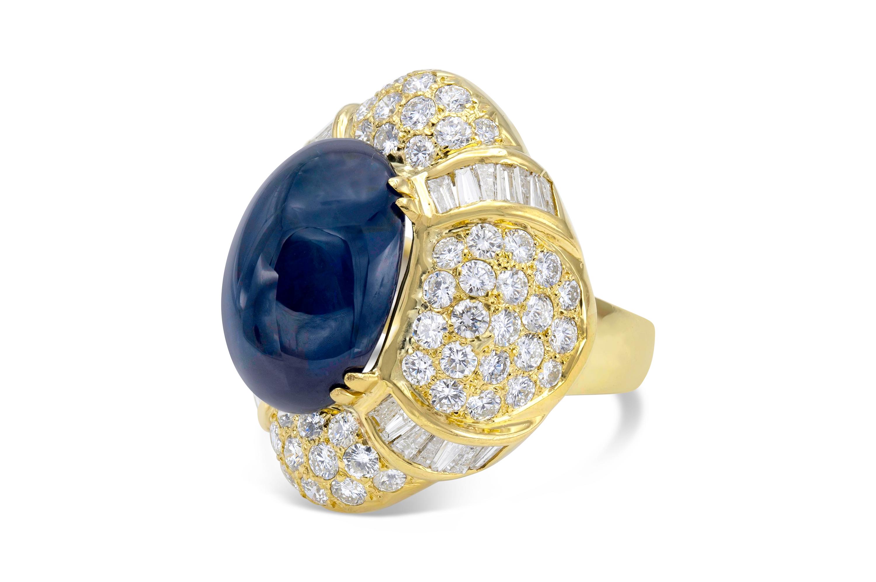 Finely crafted in 18k yellow gold with an AGTA certified 22.79 carat Cabochon Sapphire.
The ring features round and baguette-cut diamonds weighing approximately a total of 7.00 carats.
Size 7 1/2, resizable