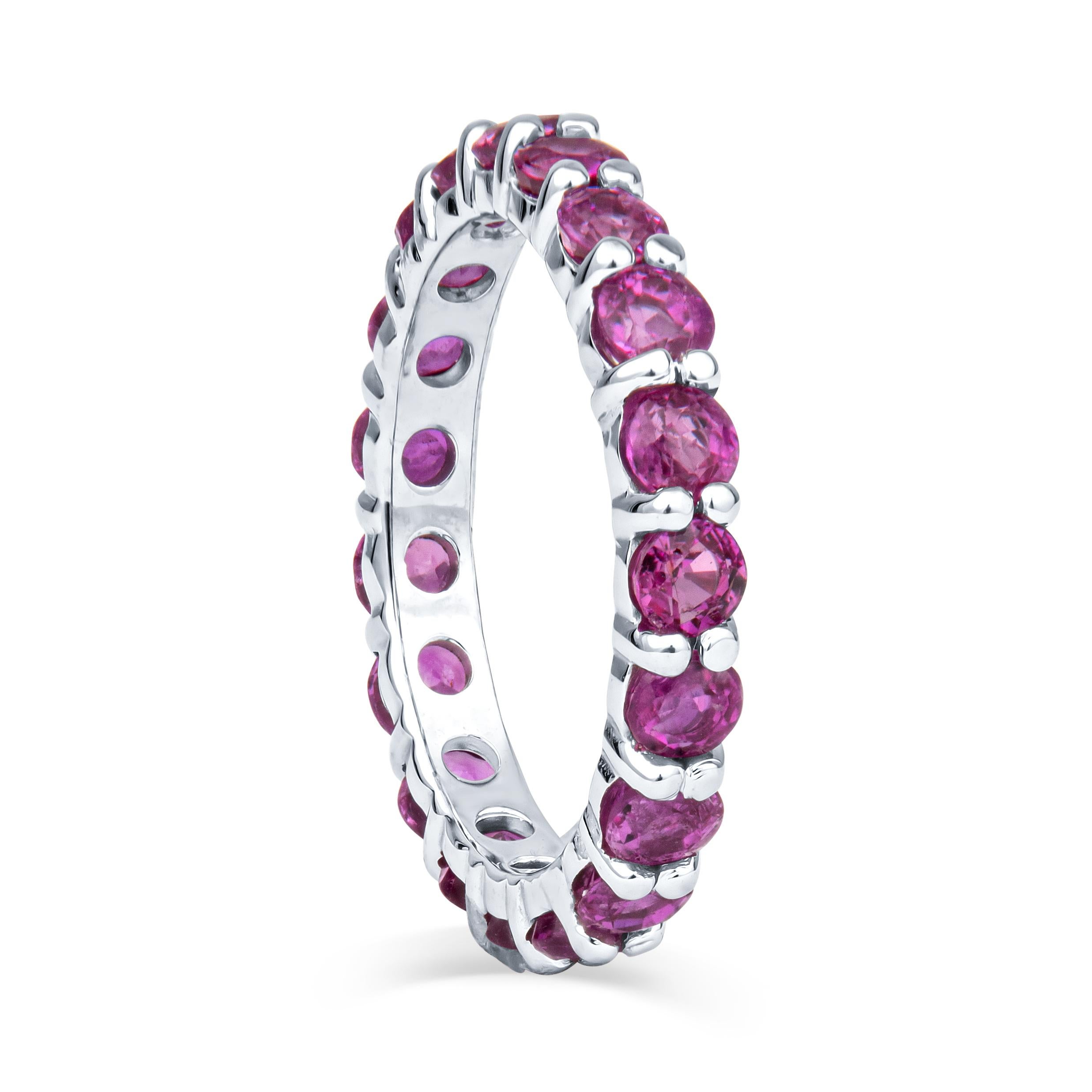 This stunning colored stone stacking band features 2.27ct total weight in round, natural, pink sapphires, set in an 18kt white gold shared prong eternity band. This beautiful ring is a perfect standalone piece, but may also be used to complement and