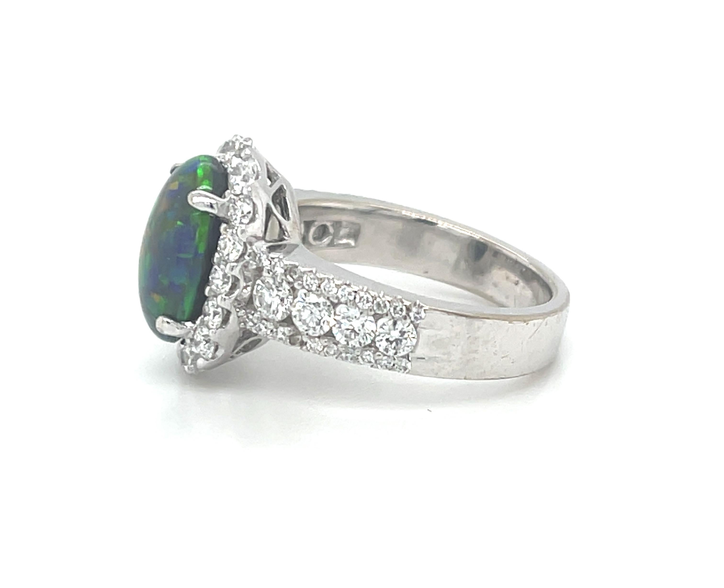 Dieser atemberaubende Cocktailring aus 18 Karat Weißgold enthält einen wunderschönen ovalen schwarzen Opal von 2,28 Karat aus der Mine Mintabie in Australien. Der Opal zeigt ein lebhaftes Farbenspiel mit auffälligen orangefarbenen, gelben, blauen