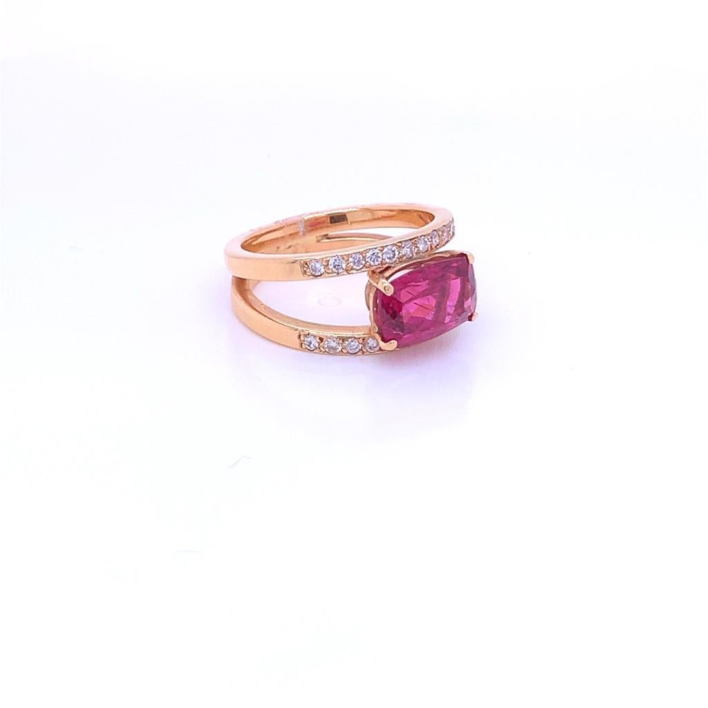 This Distinctive ring features a Flawless Cushion cut Pink Tourmaline weighing 2.28 Carats. It rests between two rows of 18K Yellow Gold embedded with Glimmering Round Brilliant Diamonds weighing a total of 0.22 carats, complementing the Tourmaline