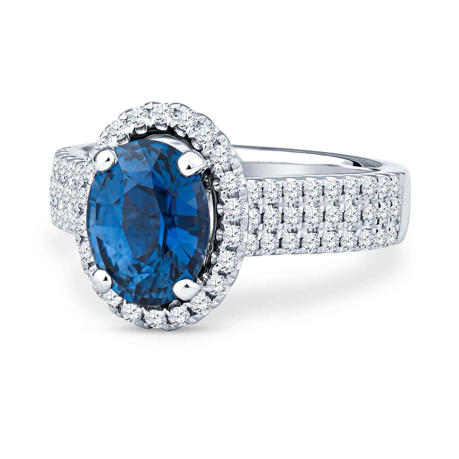 This gorgeous 2.28ct oval cut natural, beautifully saturated blue sapphire (GIA  2205618697) is surrounded by pave-set round diamonds with a 0.50ct total weight. These stones are set in a size 6 platinum oval halo ring, but can be resized upon