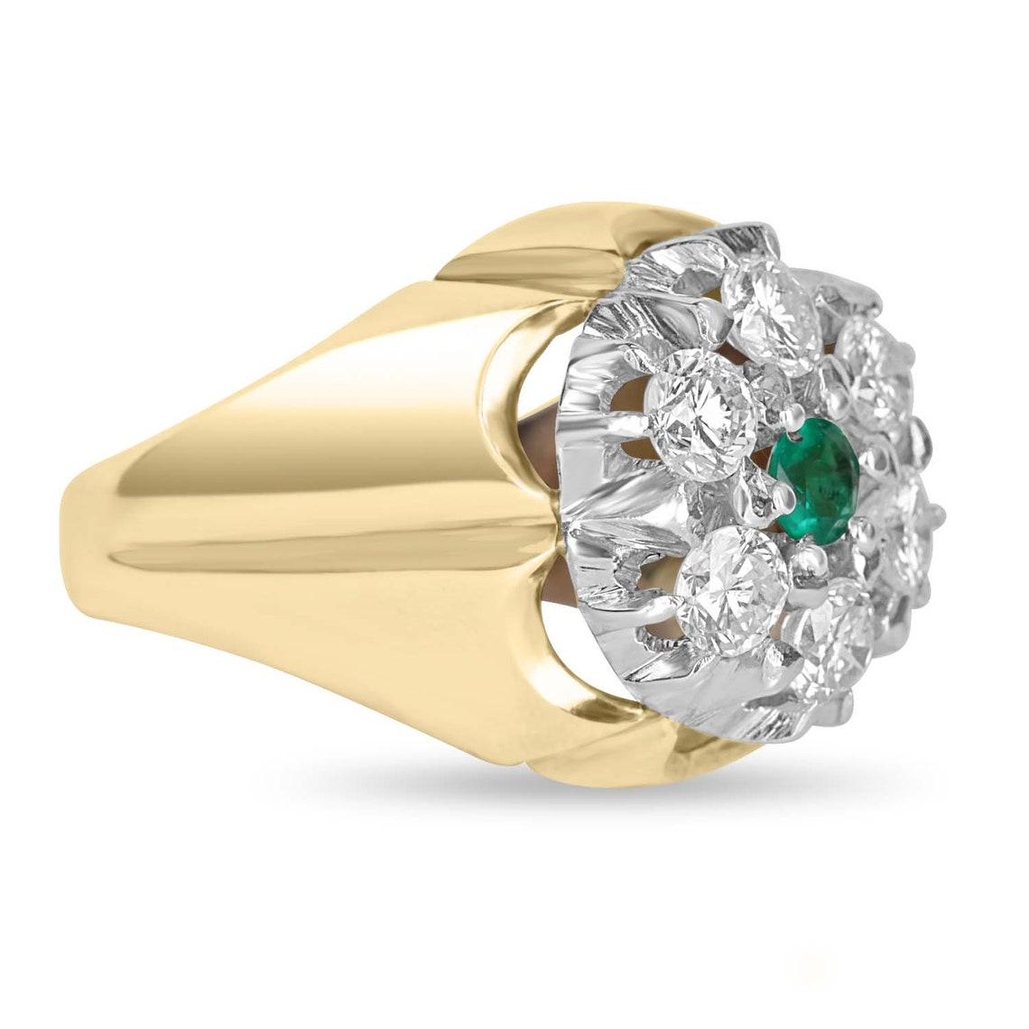 A diamond and emerald men's cluster ring. A 0.30ct round cut, Colombian emerald is set in the very center of this impressive men's ring. Six, large. brilliant round diamonds highlight the sides of the ring and create an eye-catching design. The