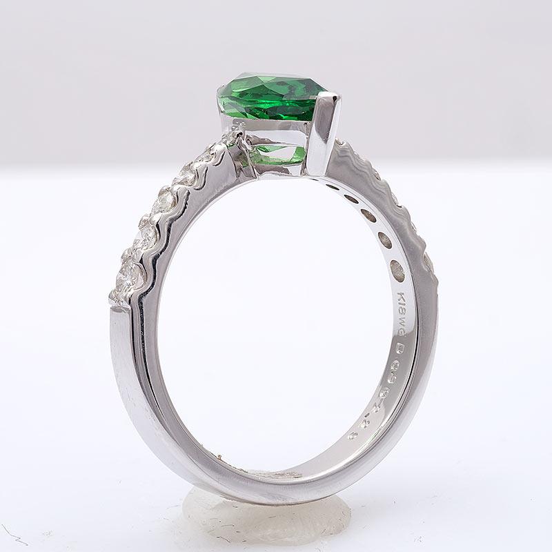 Set within an 18K white gold ring, this 2.29 carat Tsavorite, has a lush vivid green color. Known for their small sizes, the cutter has gained maximum from the rough, establishing a perfect marquise. Highlighted by the graduating diamond accents on