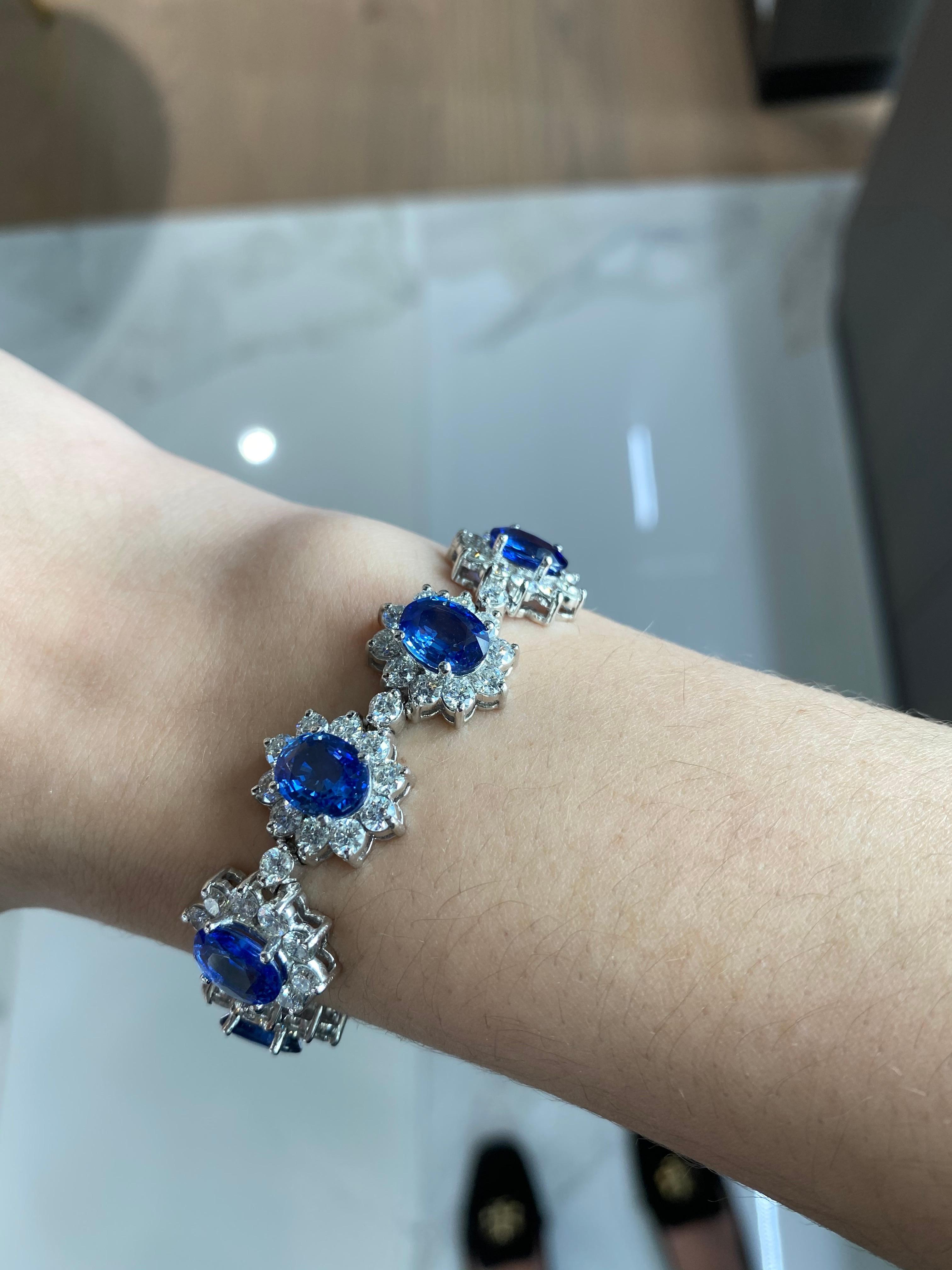 This absolutely exquisite bracelet features a whopping 22.96ct total weight in 11 oval shaped, richly saturated, blue natural sapphires, surrounded by round diamond halos forming a floral shape. The round diamonds add up to a total weight of