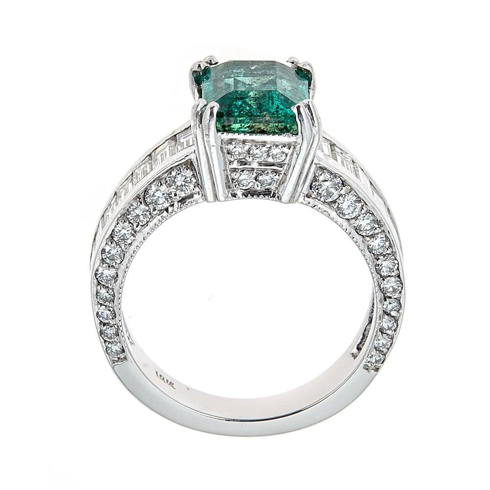 2.2 Carat Emerald and Diamond Engagement Ring 18 Karat White Gold Jewelry Size 6.7

A stunning choice for a bride to be.   Dramatic Green Emerald is centered atop of the ring in a double claw setting and accented by small baguette and round diamonds