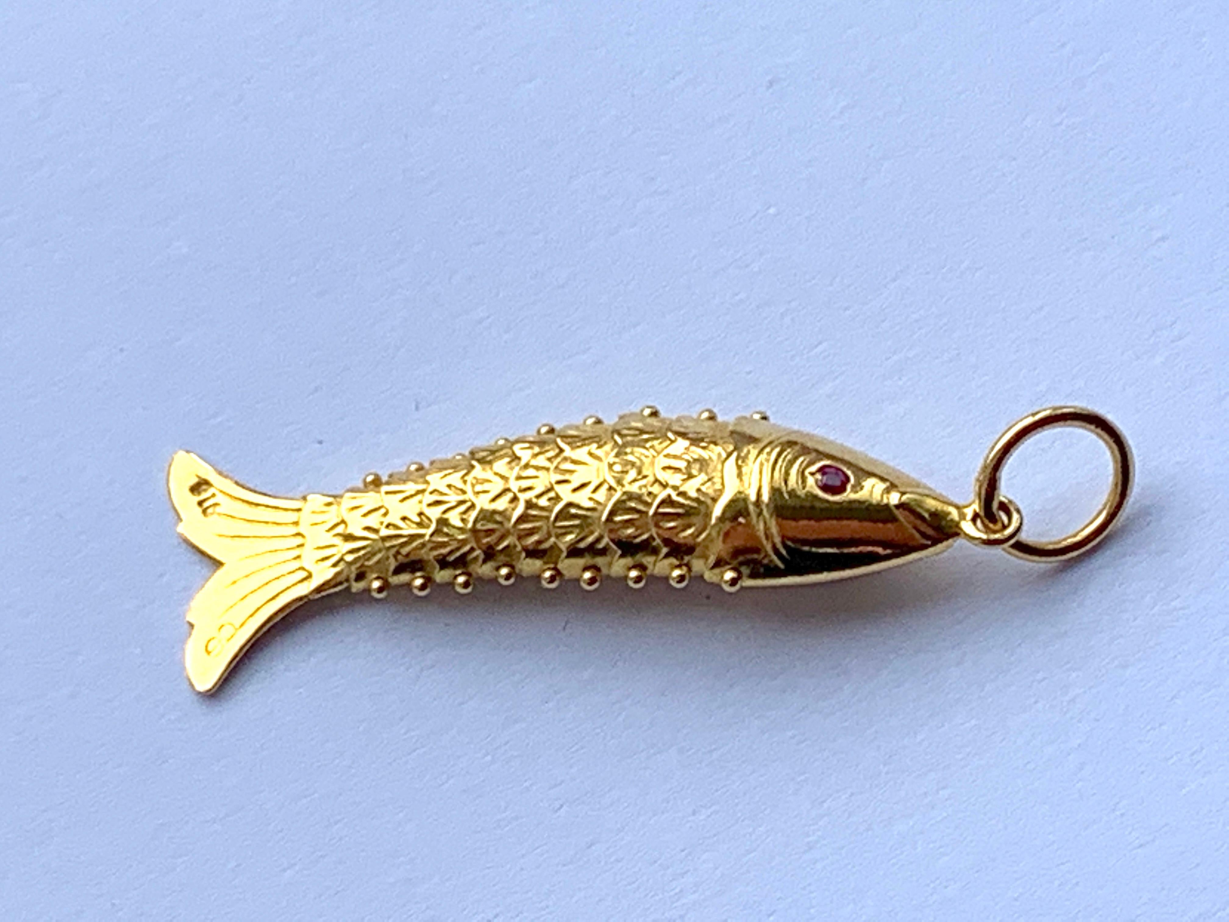 22ct Gold Articulated Fish Pendant
with genuine Ruby gemstone eyes either side.

The fish is stamped 916 on tail fin
& goldsmiths initials 