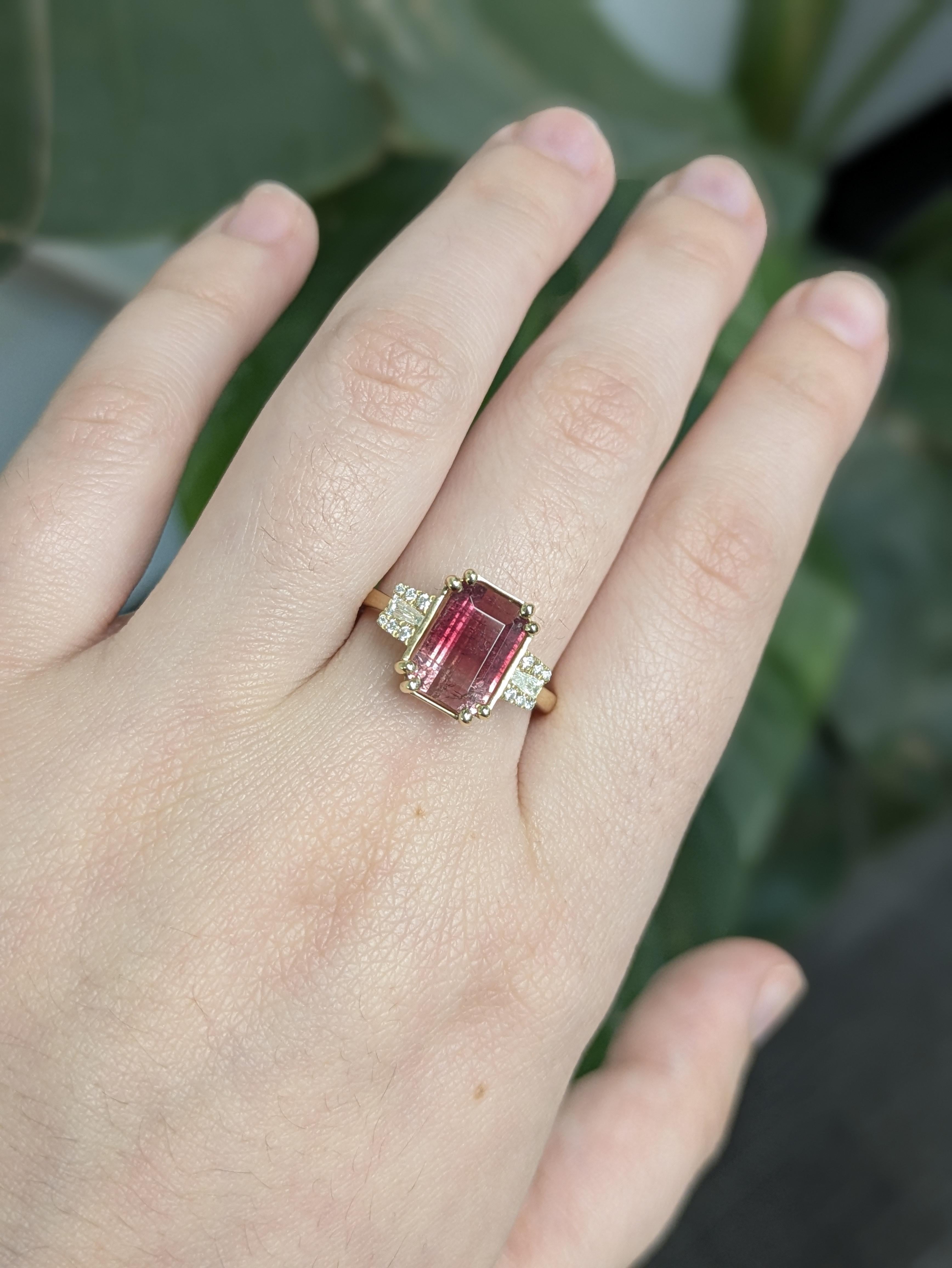 This striking ring showcases an emerald-cut bi-color tourmaline set in 14k solid yellow gold, accented with natural diamonds for added brilliance. A bold fusion of color and elegance, perfect for those who love standout style.

