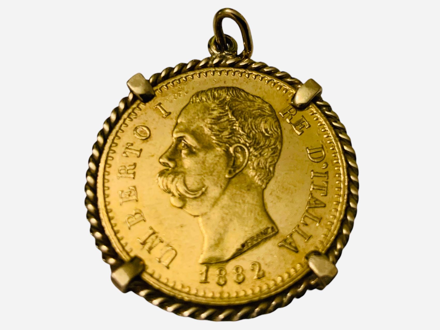 This is a 22K Gold Coin Pendant. It depicts a circa 1882 Italian yellow gold coin mounted and adorned with a braided gold frame. One side portray an Italian shield 20 L and the other one, the profile of Umberto I Re D’Italia 1882.