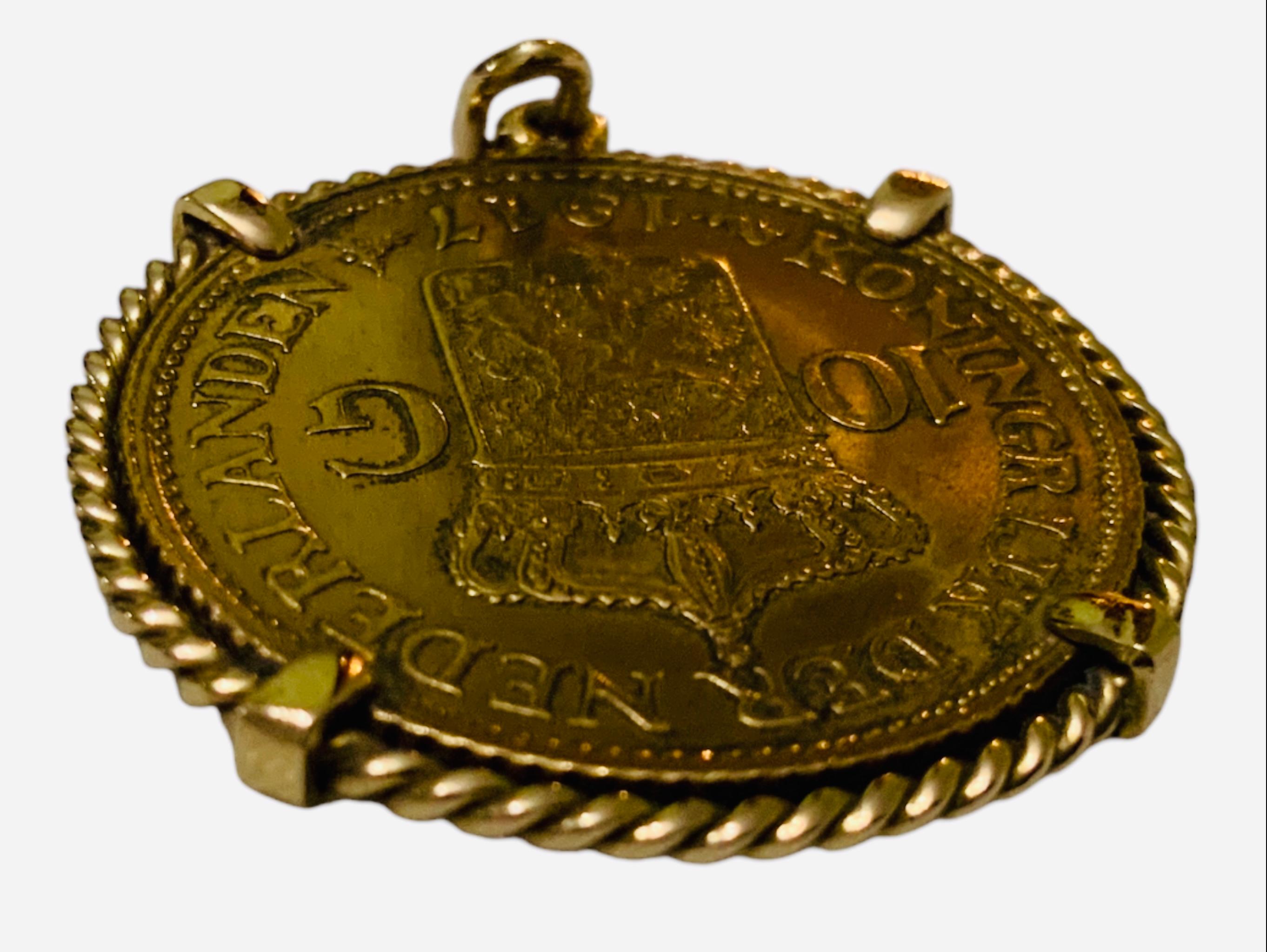 This is a 22K Gold Coin Pendant. It depicts a circa 1917 Netherland yellow gold coin mounted and adorned with a braided gold frame. One side portrays a Netherland shield Kroningrijk Der Nederlanden 1917, 10 G and the other one, the profile of 