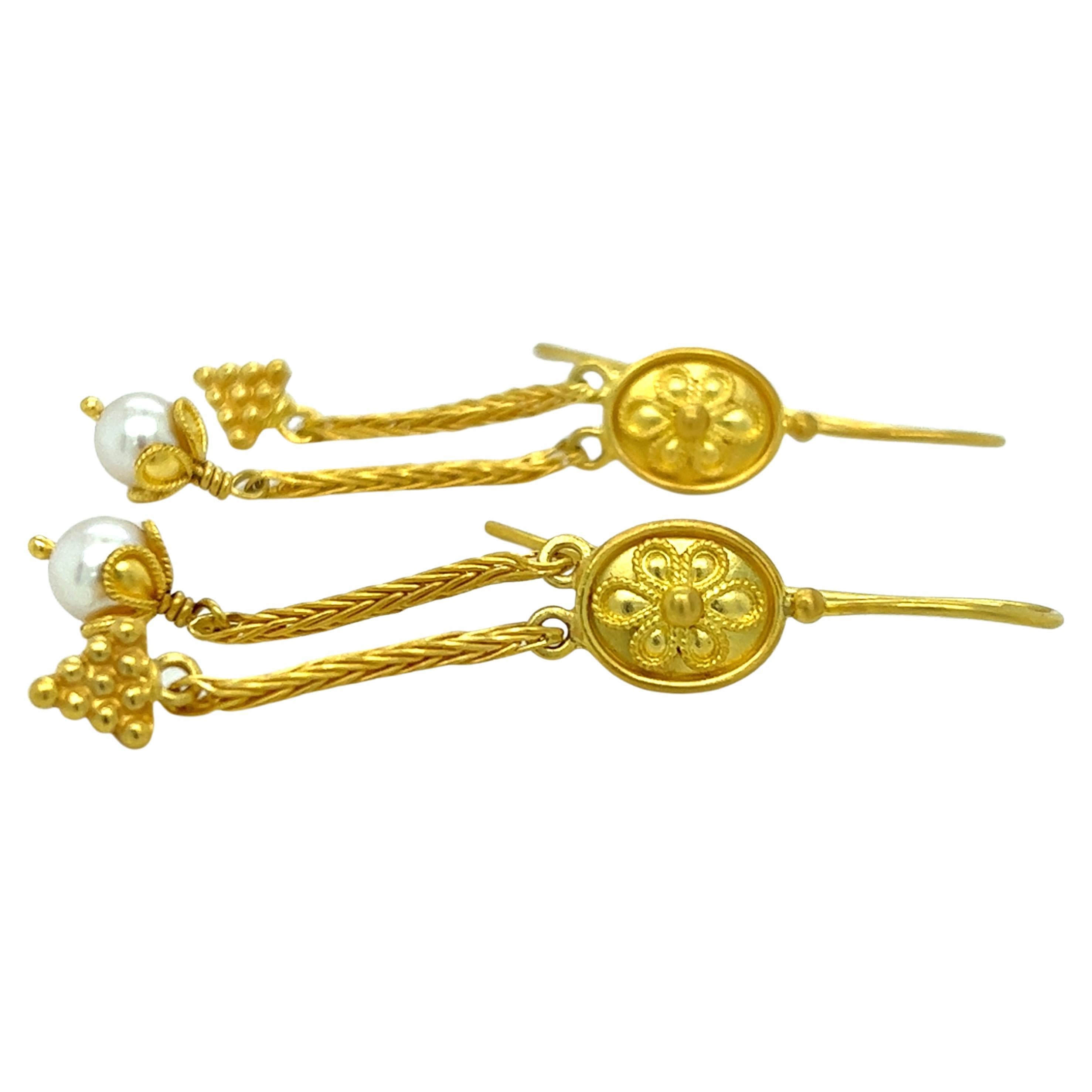 
One pair of 22-karat yellow gold ancient Greek revival design earrings, each set with one freshwater pearl, measuring 2.25 inches long complete with traditional hook closures.