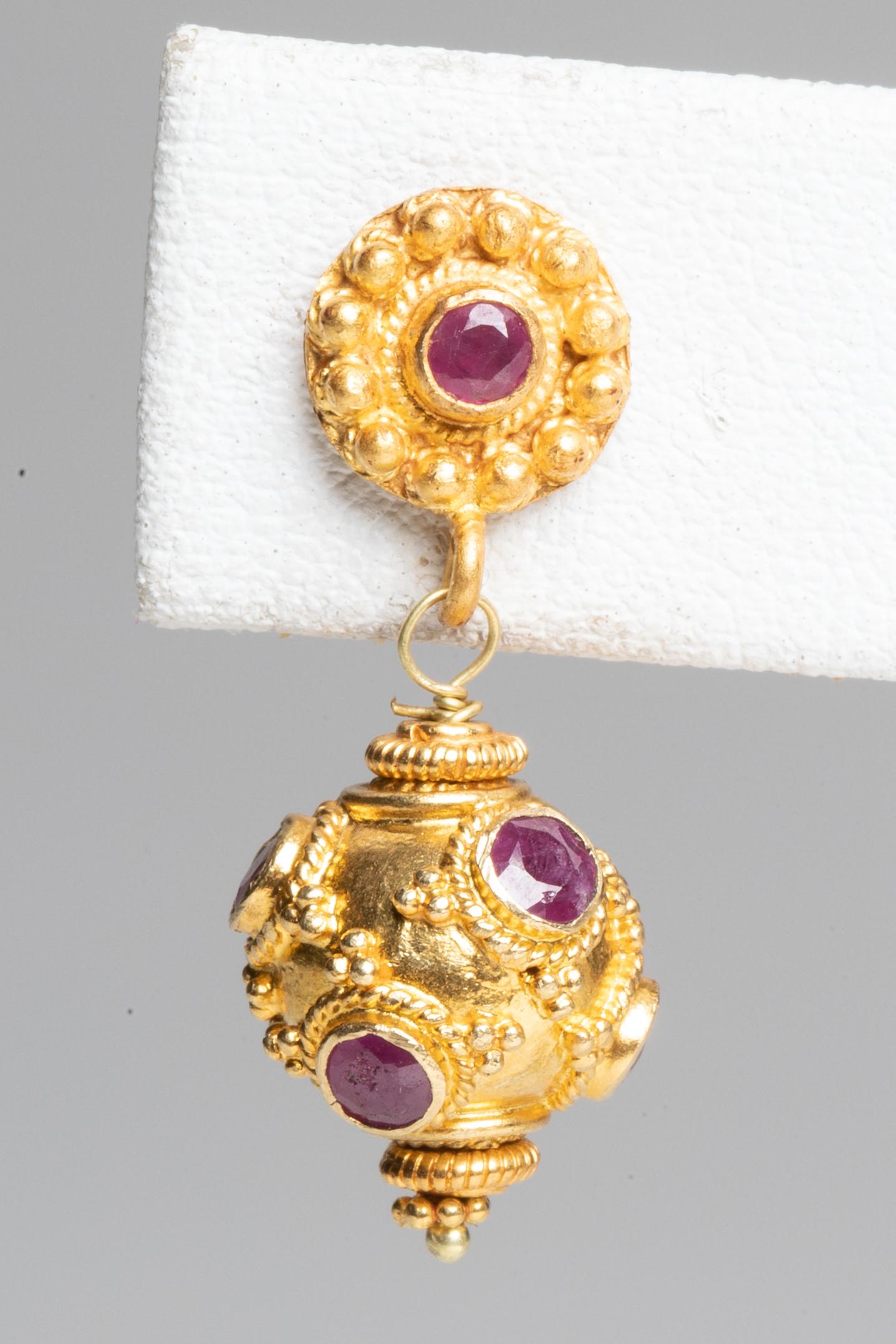 A pair of 22K gold bead drops with fine hand tooling and faceted Burmese rubies all around.  22K gold post also with faceted Burmese ruby, for pierced ears.  By Deborah Lockhart Phillips