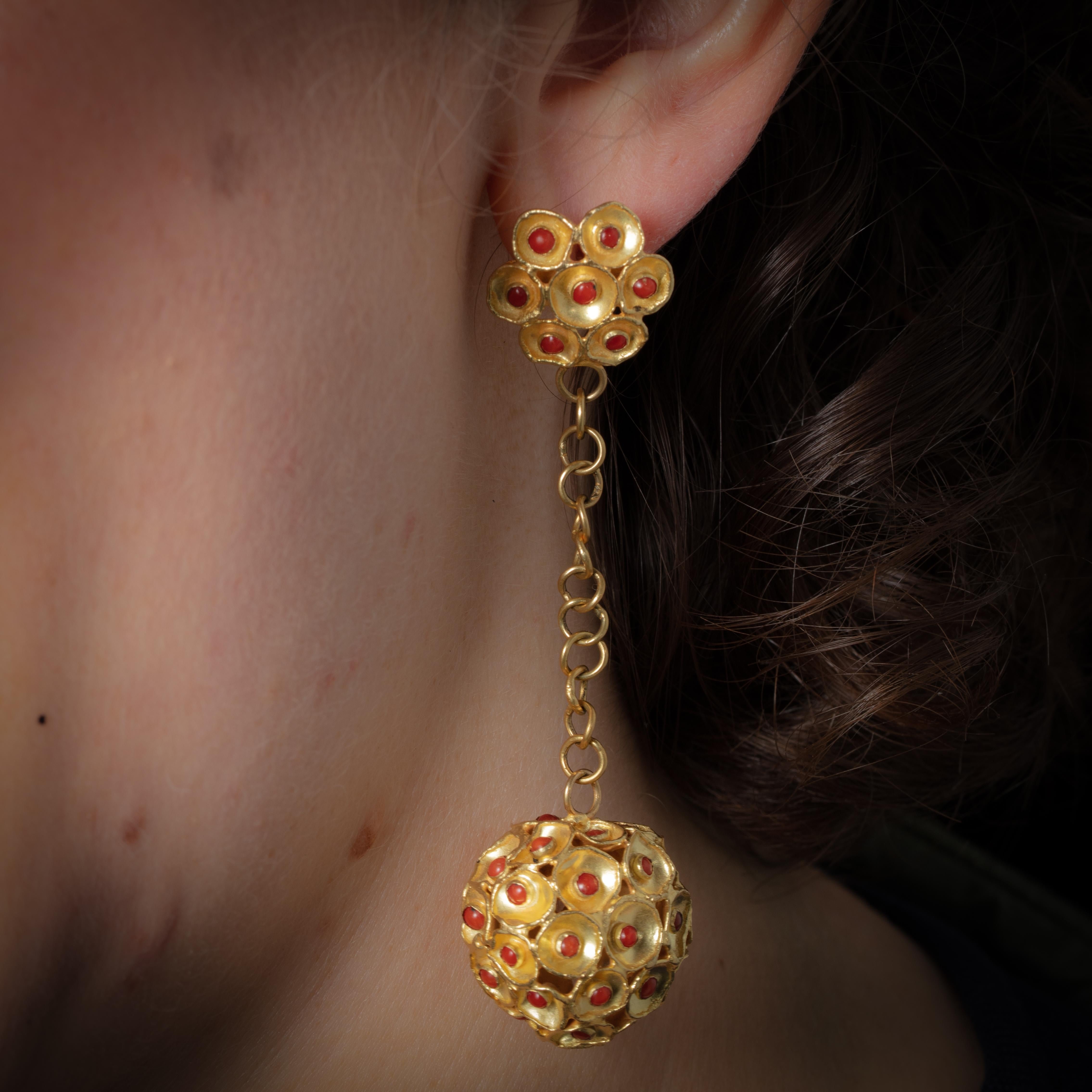 Une étonnante paire de boucles d'oreilles en or 22 carats avec un motif de fleur sur le poteau avec du corail et une boule texturée en or et corail tombant d'une chaîne en or 22 carats.  Tous les produits sont fabriqués à la main.  Pour les oreilles