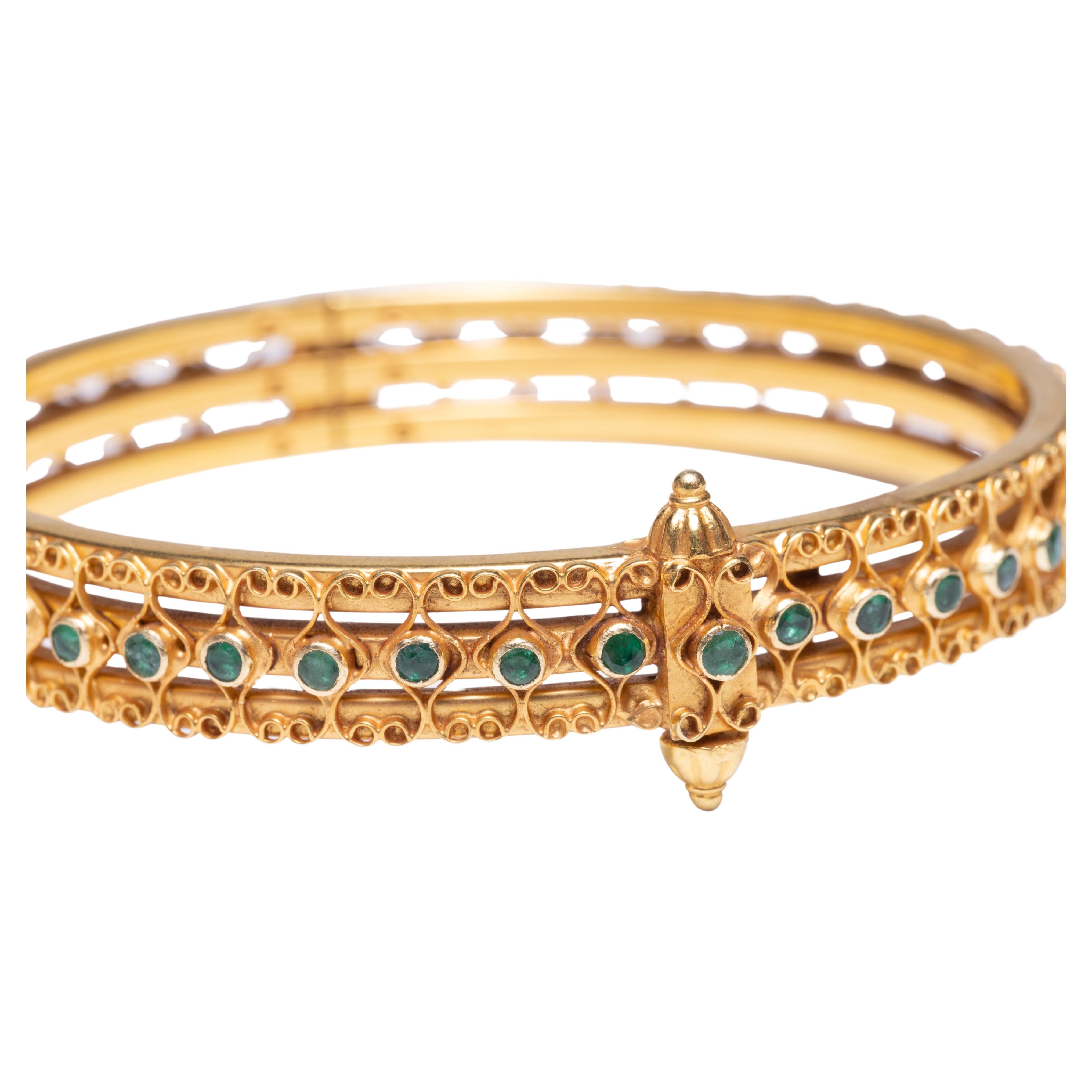 18K Gold bangle bracelet with faceted, round emeralds all around.  Intricate wire work by highly skilled and talented Indian goldsmiths.  Hinged for easy on and off.  Clasp is a screw at the top (that will not come out all the way keeping it safe