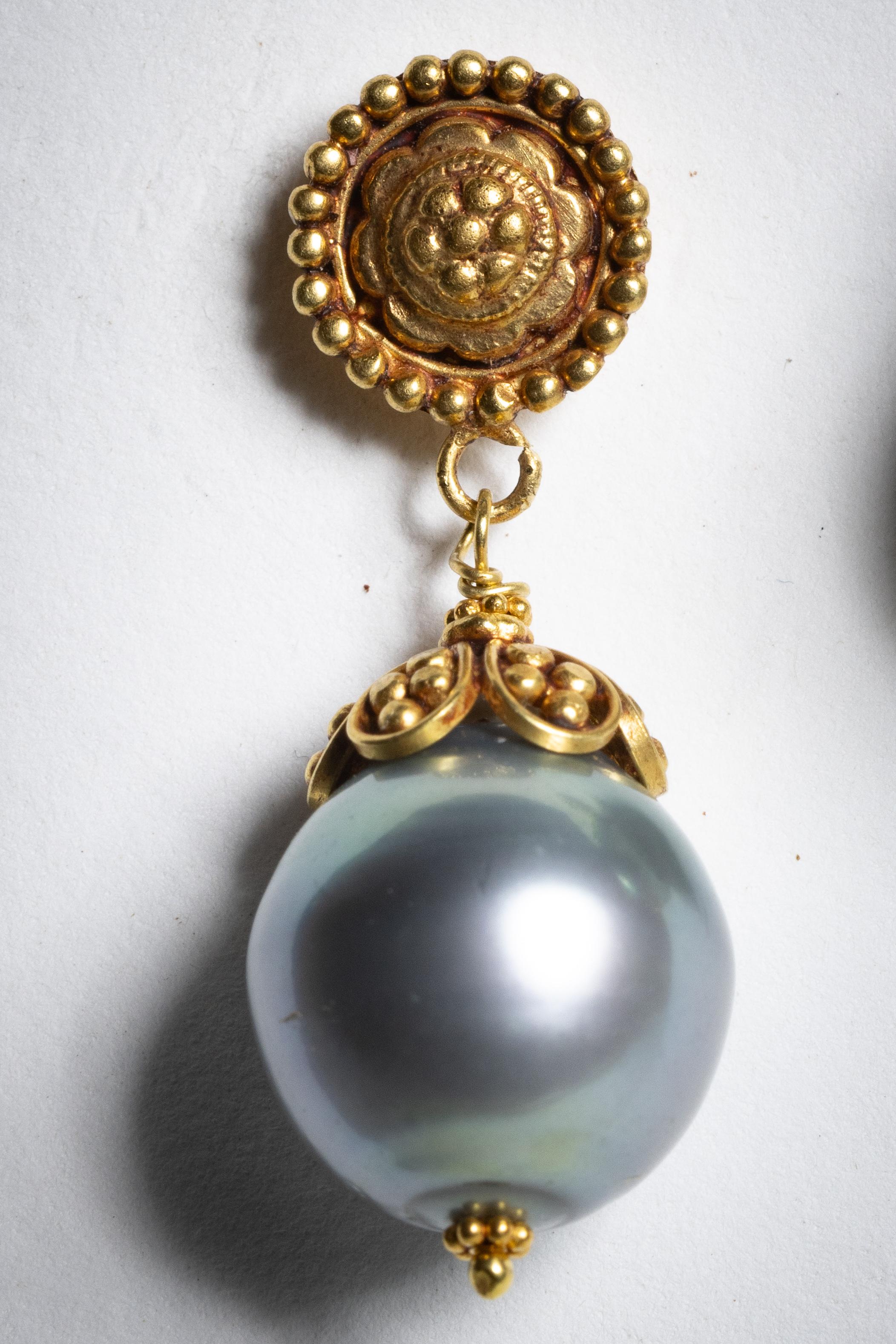 A pair of classically different pearl drop earrings.  These feature fine hand-tooling on the stud and end cap with a 16mm Tahitian pearl.  For pierced ears.  By Deborah Lockhart Phillips.

The fine jewelry collection is sourced, designed or created