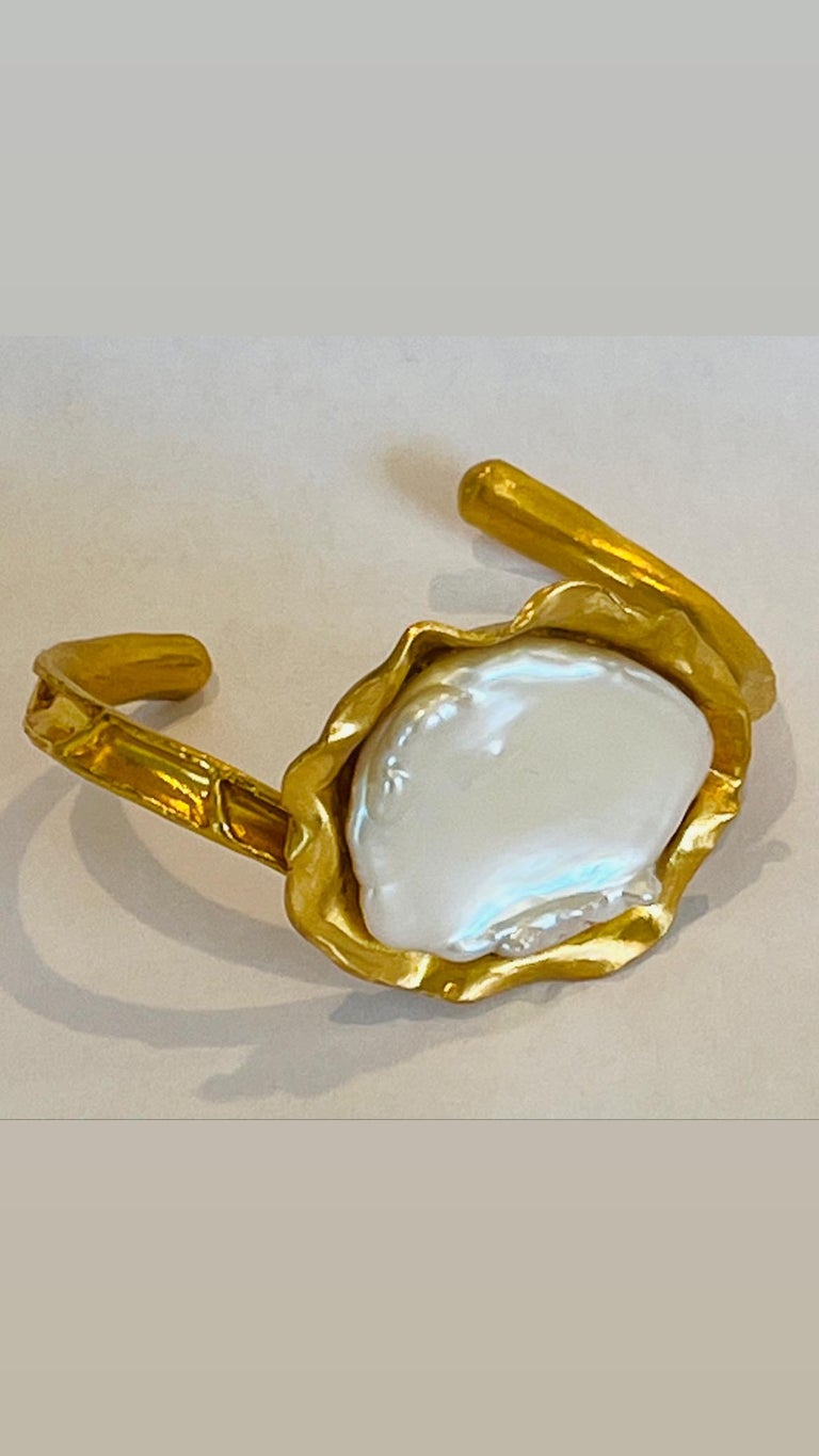 22k gold baroque coin pearl cuff is a hand made, hand carved one of a kind stunner! The cuff itself is intricately carved and the bed of gold the pearl sits in is inspired by the Ocean, the Coral Reef. The Pearl Collection represents the beauty,