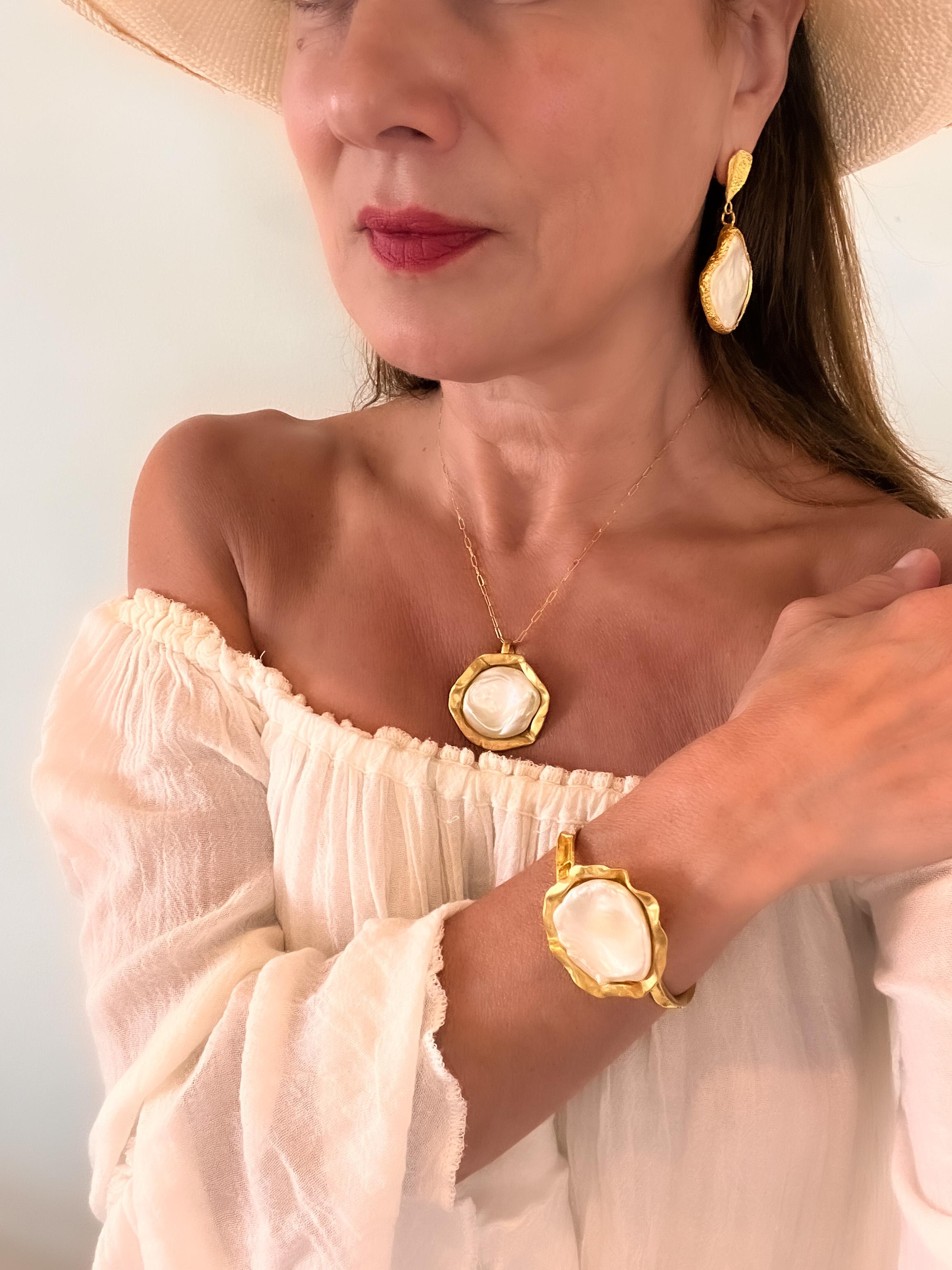 22k gold baroque coin pearl cuff is a hand made, hand carved one of a kind stunner! The cuff itself is intricately carved and the bed of gold the pearl sits in is inspired by the Ocean, the Coral Reef. The Pearl Collection represents the beauty,