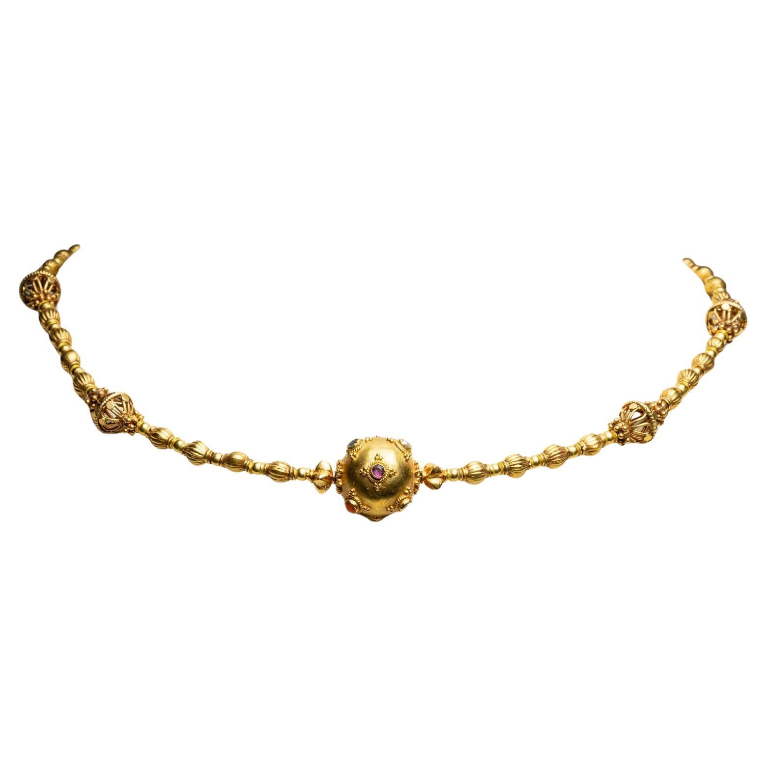 Una semplice ma beneaugurante collana di perline in oro 22 carati.  La perlina centrale misura 1/2