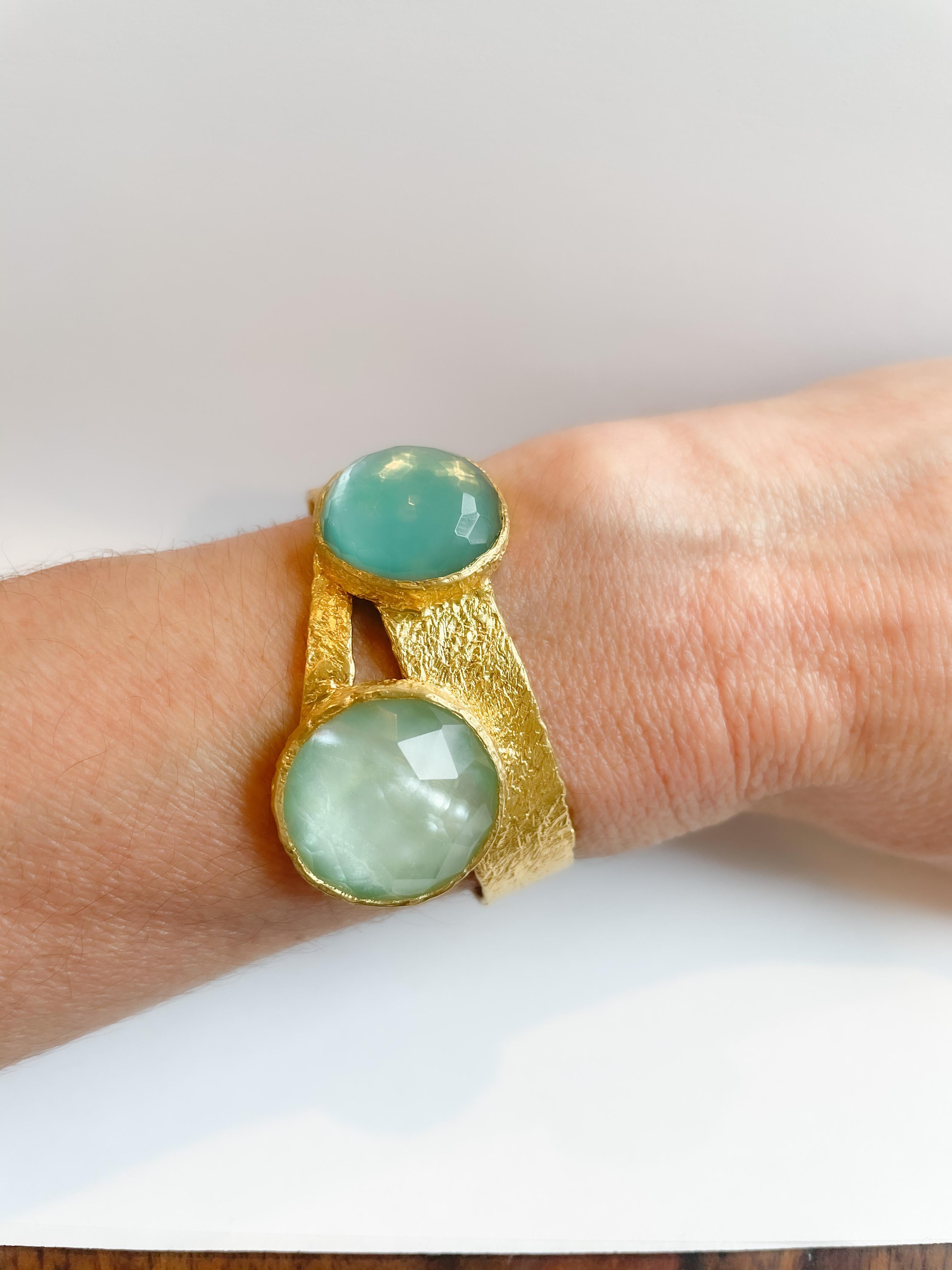 The Eclipse 22k gold cuff features 2 beautiful sliced stones both with Quartz on top and one with Turquoise and other with Mother of Pearl behind. The combinations of these stones together results in absolutely beautiful pop of color and a