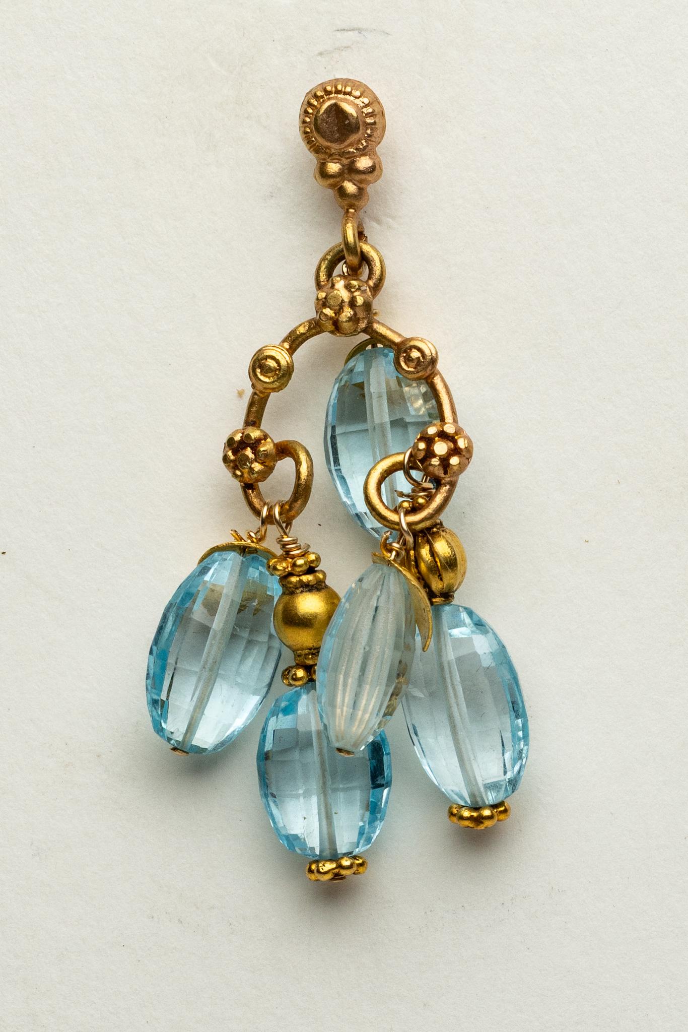 Coppia di squisiti orecchini chandelier in oro 22K con grappoli di cinque gemme ovali sfaccettate di topazio blu abbinate a perline d'oro che creano consistenza e interesse.  Perno in oro per orecchie forate.  Di Deborah Lockhart Phillips.

La