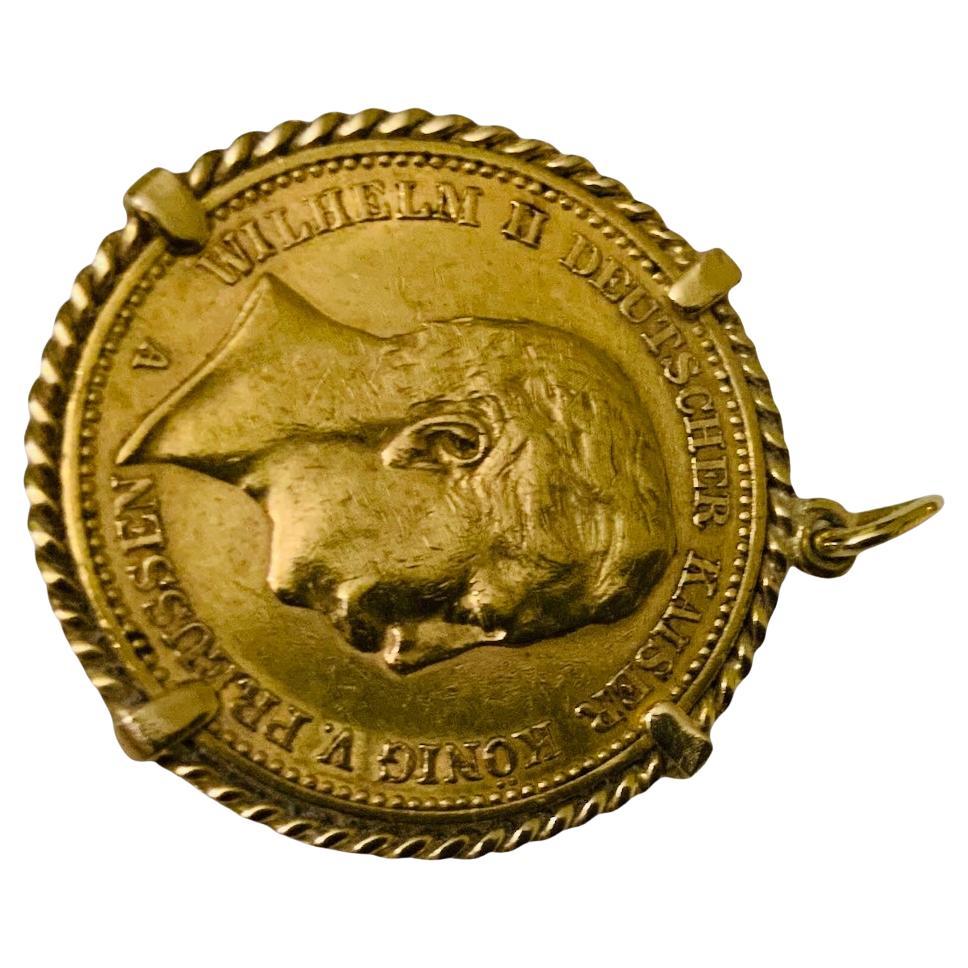 This is a 22K Gold Coin Pendant. It depicts a circa 1905 Deutsches yellow gold 20 Mark coin mounted and adorned with a braided gold frame. One side portray the shield of Germany Deutsches Reich 1905, 20 Mark and the other one, the profile of Wilhelm