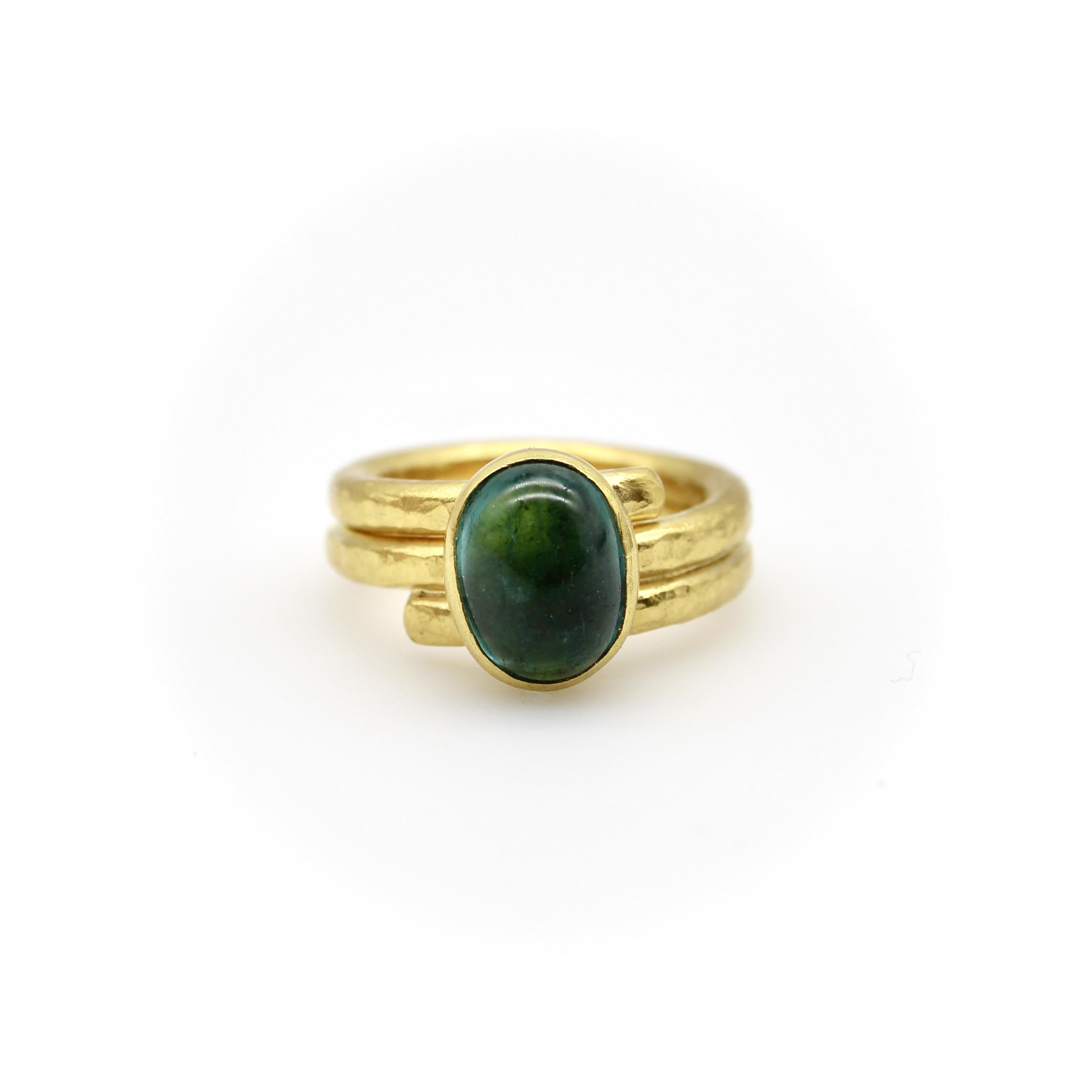 Cette bague en or 22k présente un design simple qui met en valeur la beauté de son cabochon de tourmaline bleu-vert. Un long morceau de fil d'or épais a été roulé puis martelé à la main pour prendre forme, et se contourne au centre, où la pierre