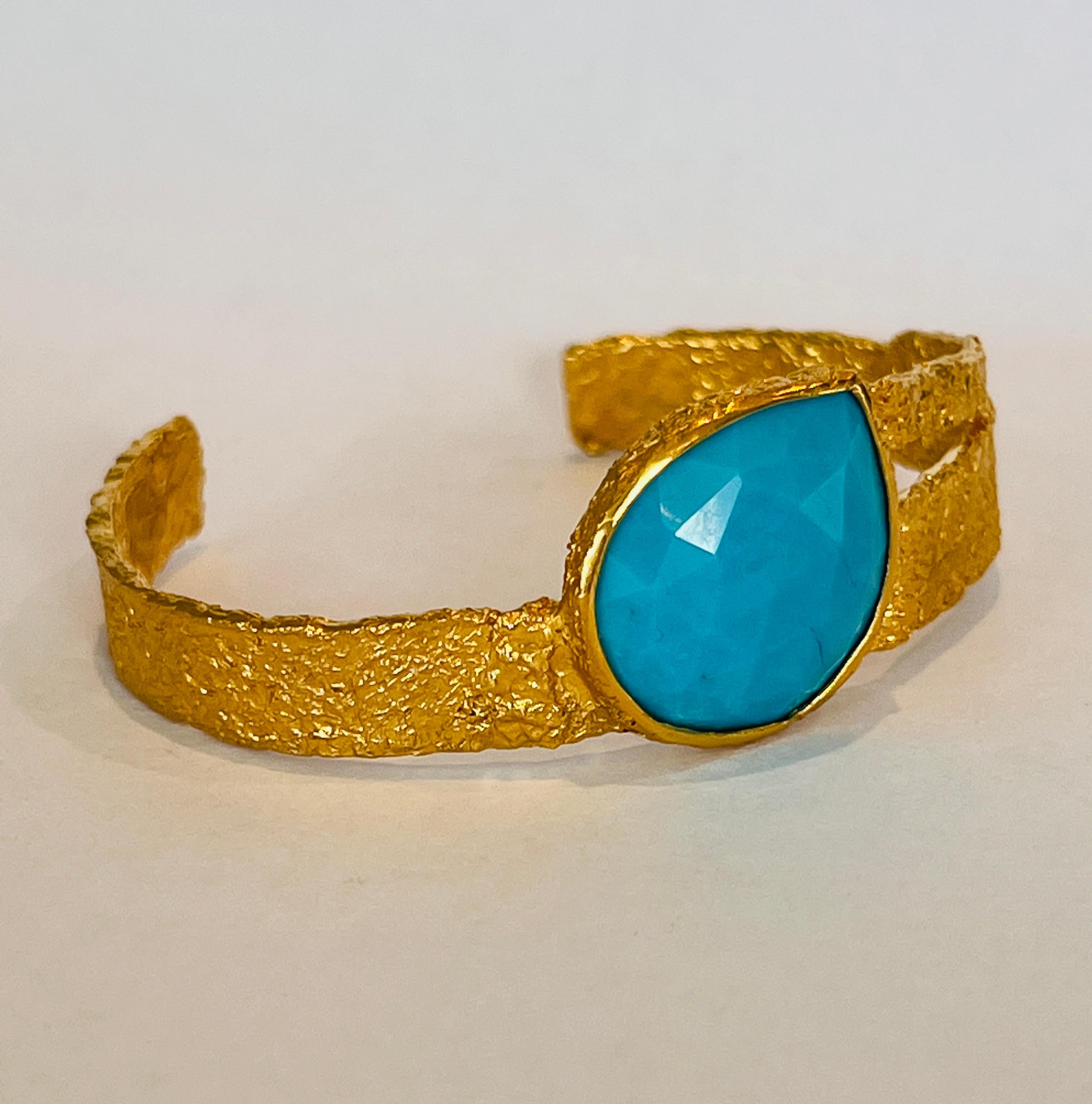 22k gold cuff is a one of a kind stunner that is carefully handmade and features a beautifully set pear shaped turquoise stone. Significant attention to detail is made with the combination of Tagili’s signature finish and the vibrant color of