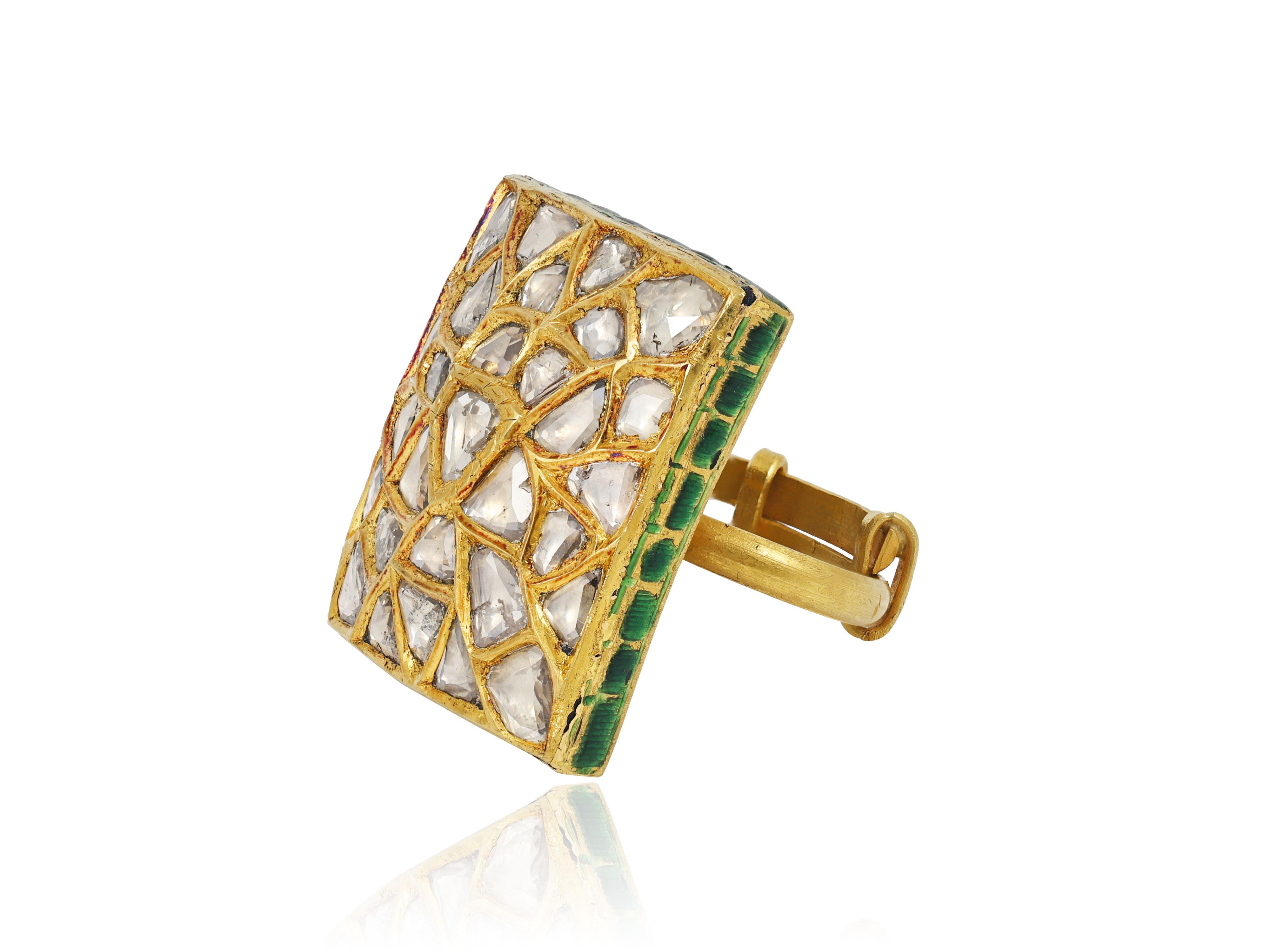 A 22K gold ring with its top in rectangular form studied with many uncut diamonds. The diamonds are of natural origin and are facetted at the top to give them lustre. The top part is studded in 24K gold with an old Kundan technique native to