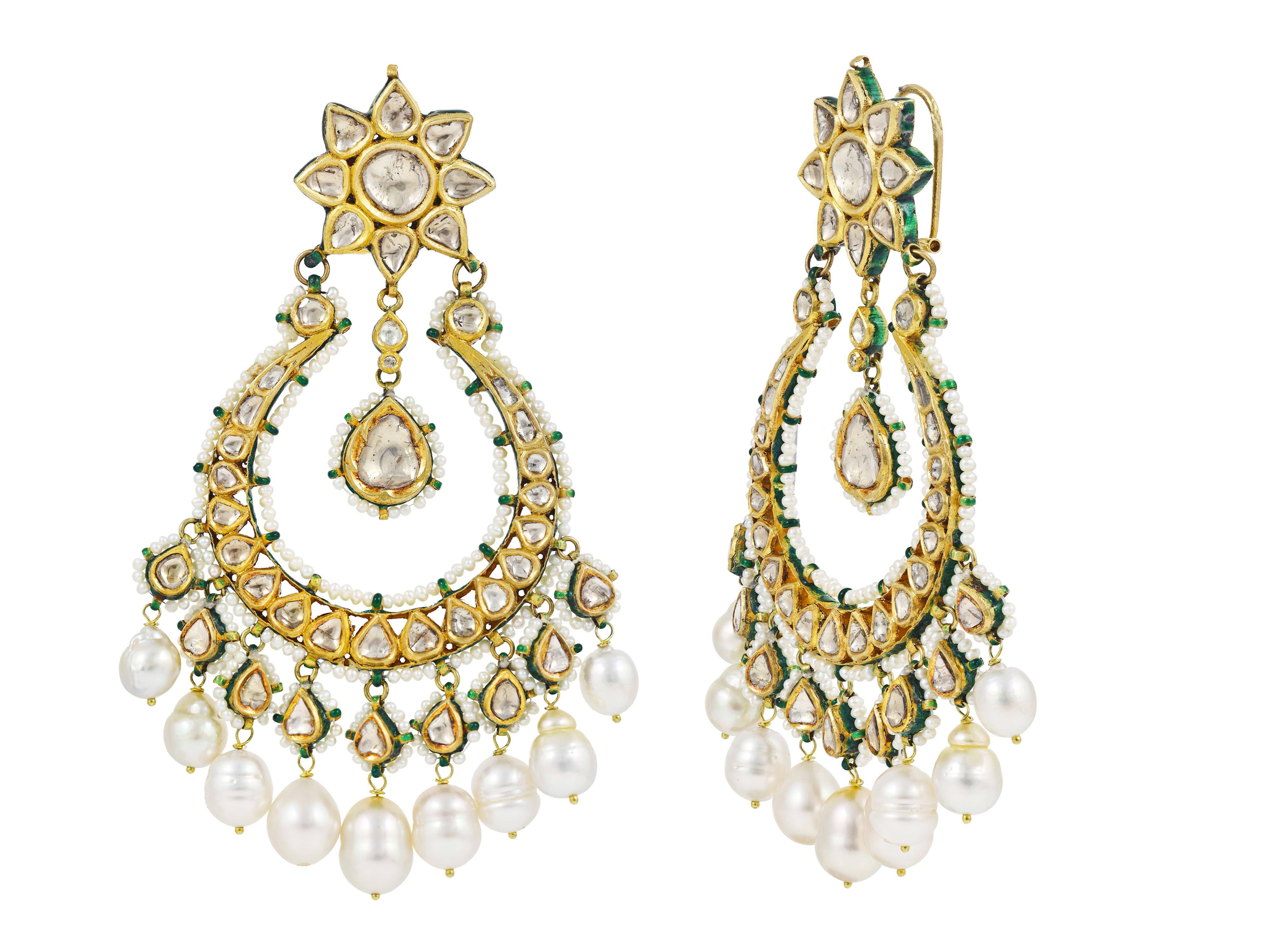 A pair of earrings handcrafted in 22K gold with diamond polkis at the front. These type of earrings are also know as chand Balis due the shape of the lower hangings which are in form of crescent shape moons. 


The studs are in form of 8 petal